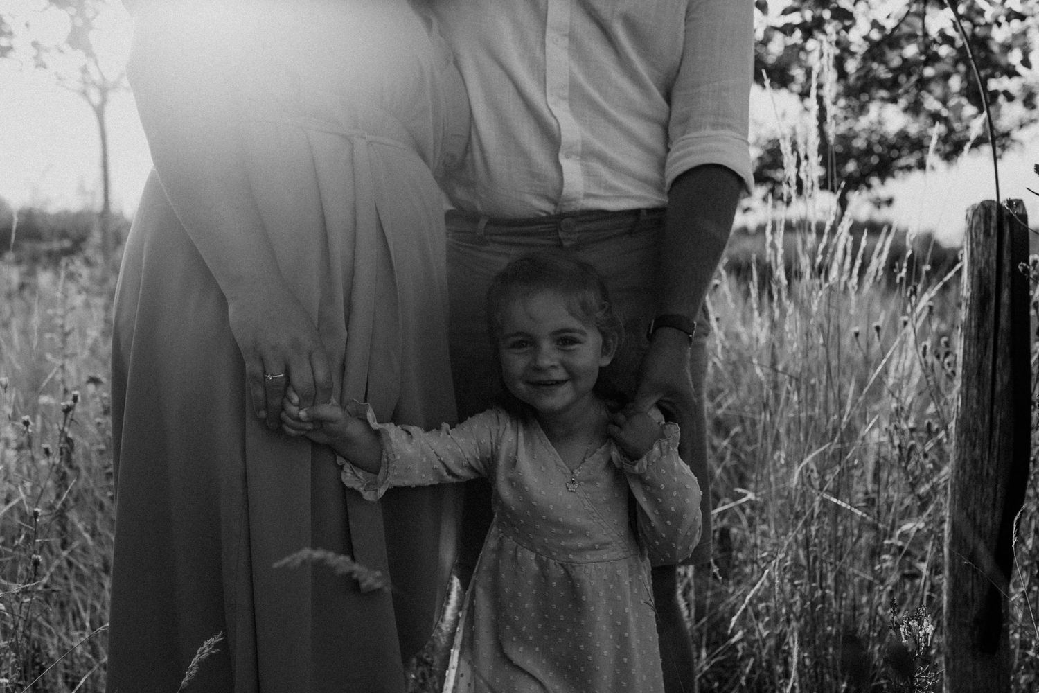 A black and white photo collage showing candid moments of people in nature with tall grass and outdoor settings.