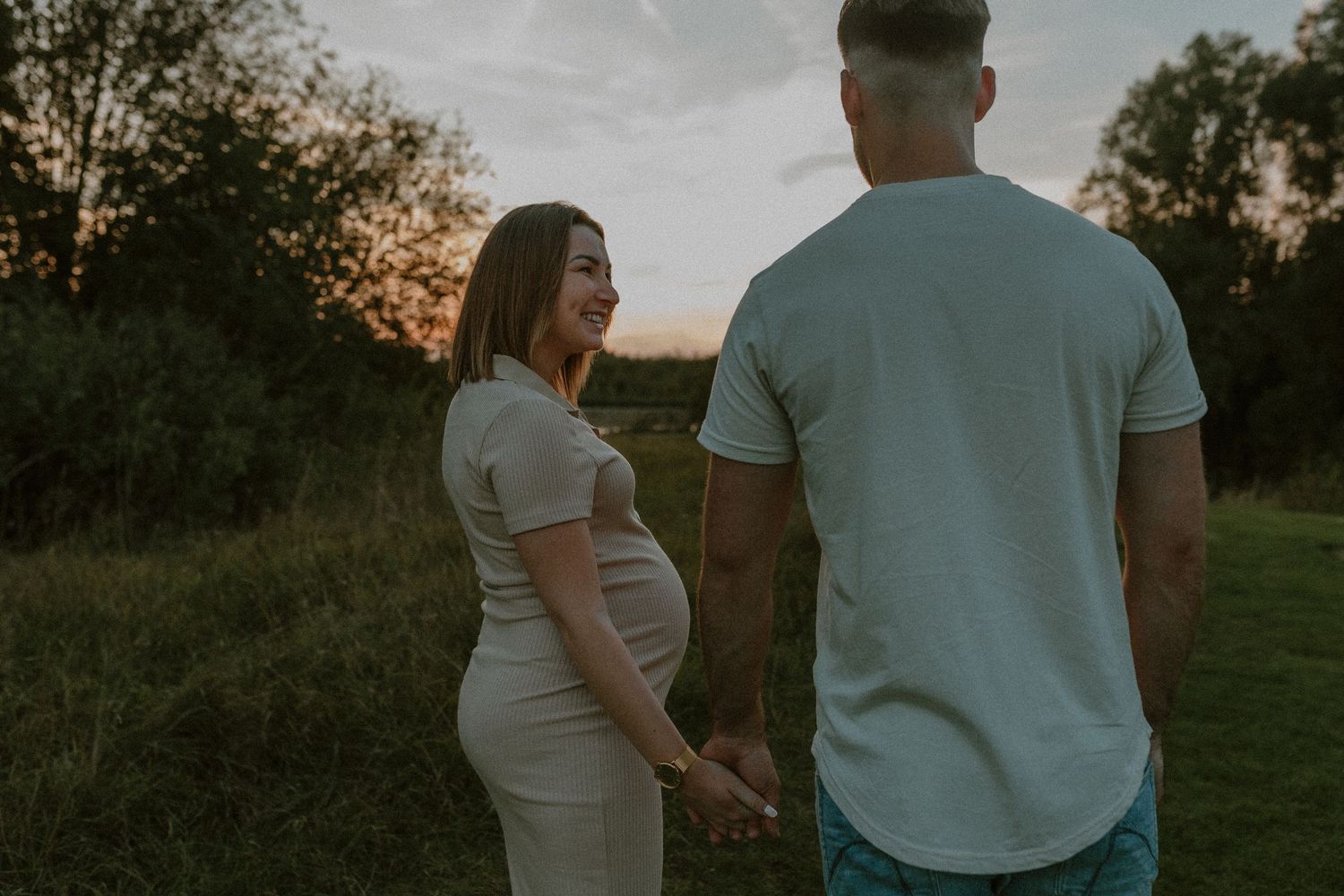 Couple holding hands while walking through a scenic field at sunset, captured in multiple romantic poses.