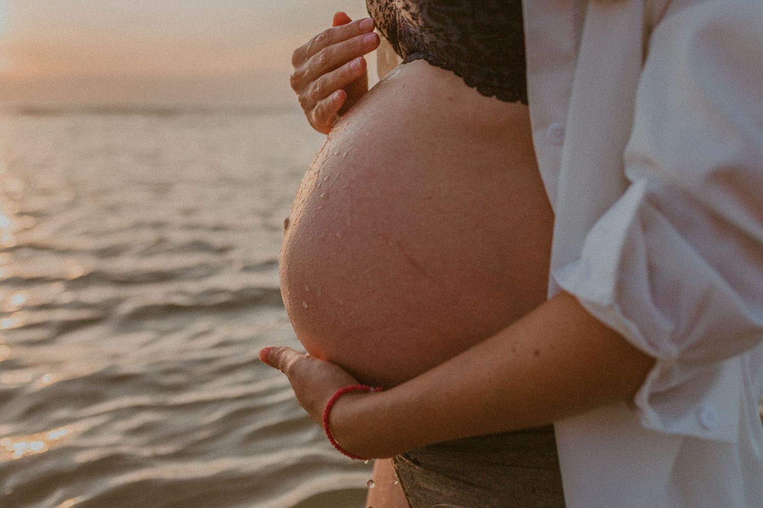 A series of maternity photos showing a pregnant belly at sunset on the beach, captured in warm golden light.