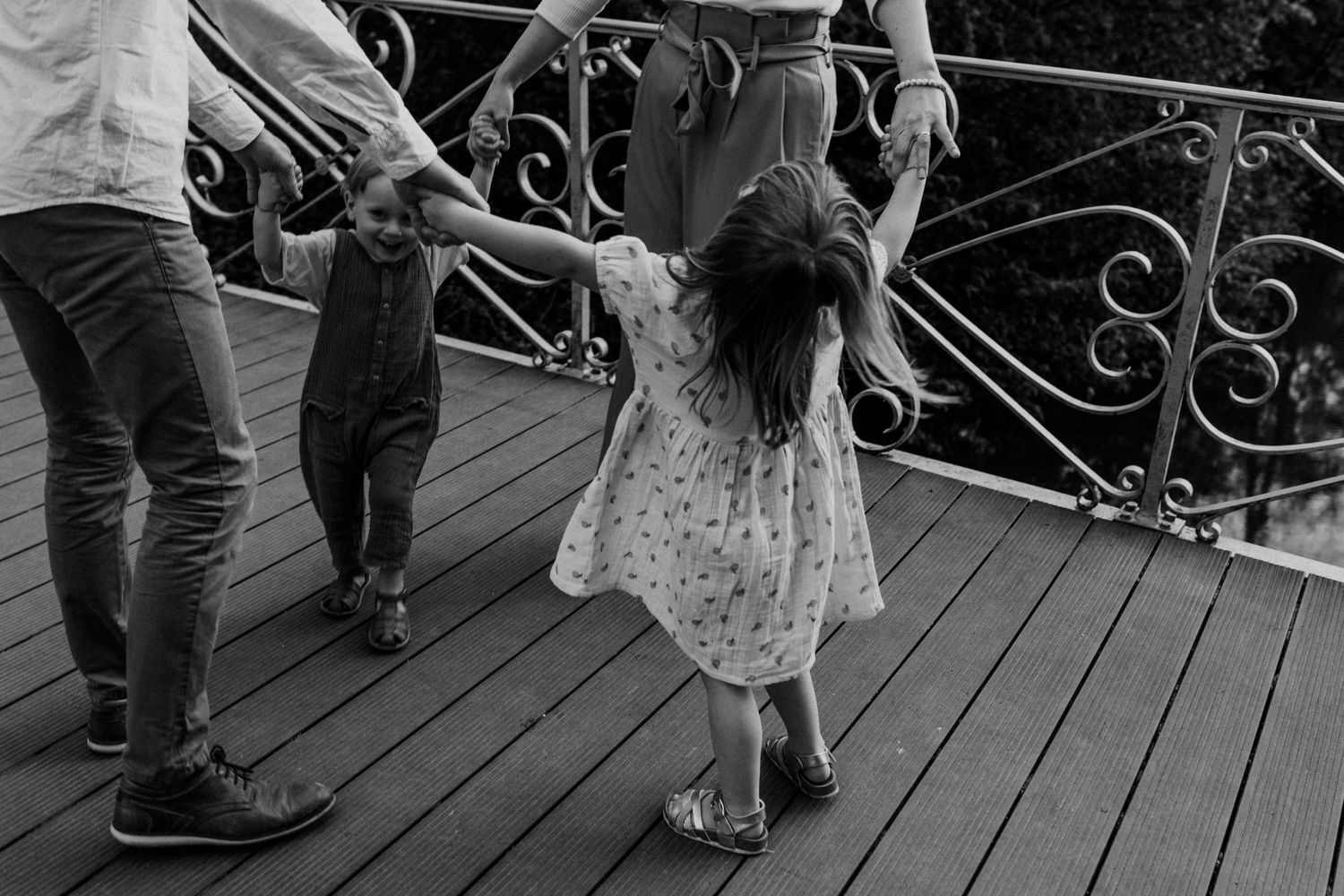 People dance and celebrate at an outdoor wedding reception on a rustic wooden deck.