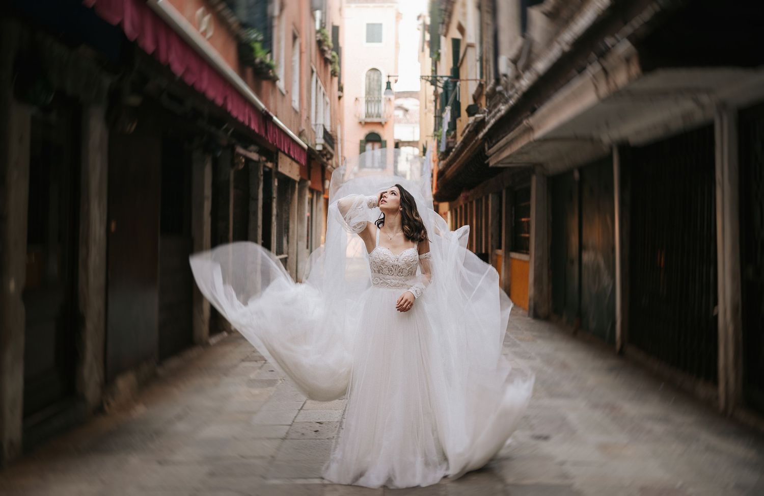 Bride walking through a quiet Venetian alley during a post-wedding photoshoot in Venice, Italy