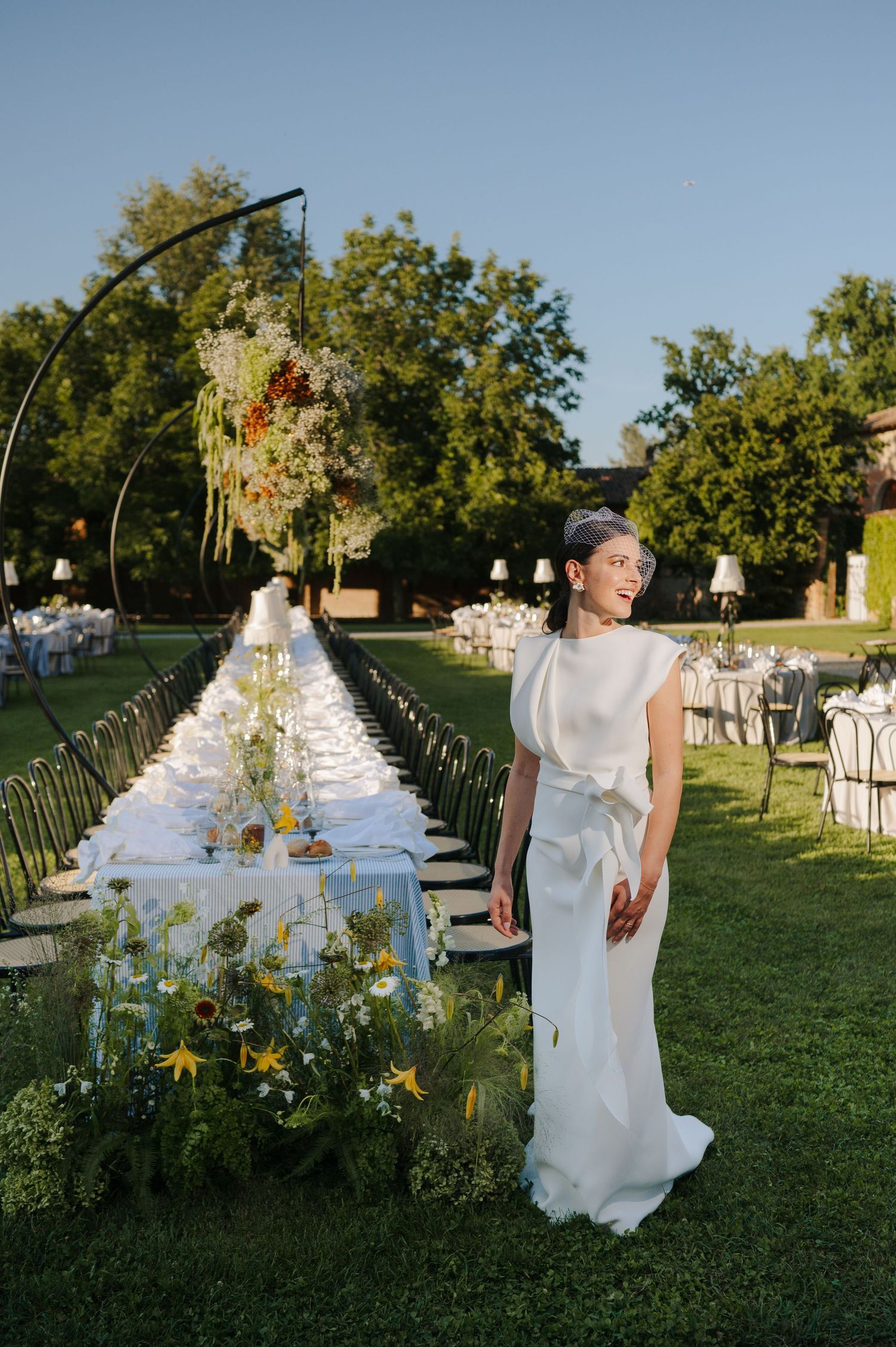 Bride standing beside a beautifully styled wedding table at a luxury destination wedding in Tuscany