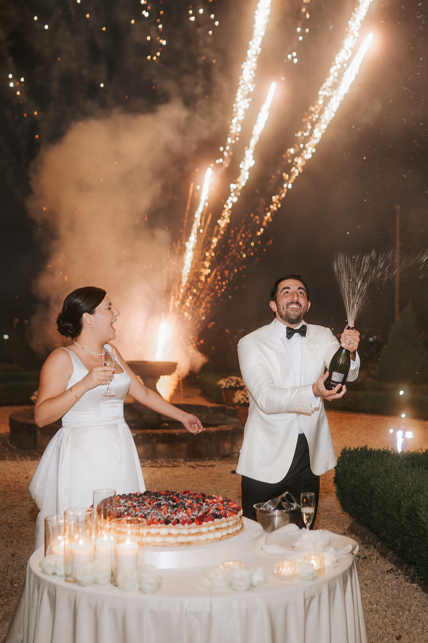 Wedding celebration moment with cake and fireworks, capturing joy and atmosphere during an elegant evening reception