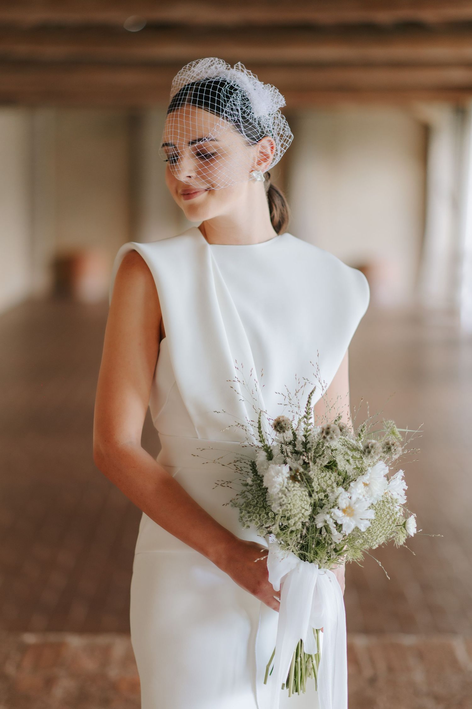 Minimal and elegant bridal portrait holding a bouquet during a luxury wedding in Tuscany