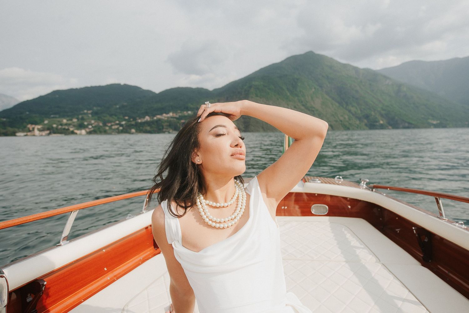 Editorial bridal portrait on a wooden boat during a luxury Lake Como destination wedding