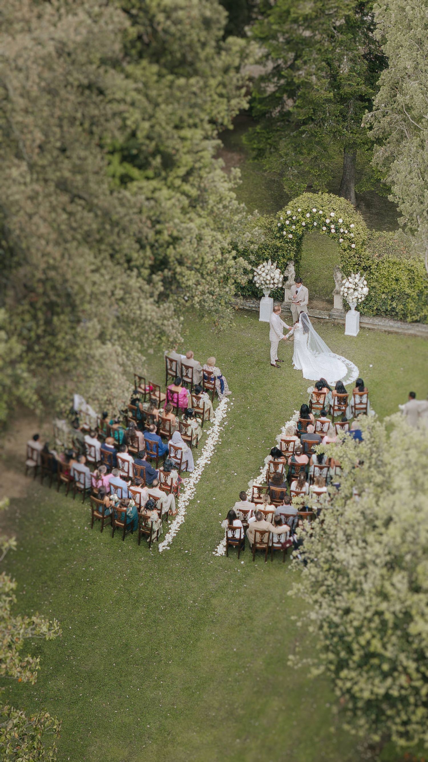 Outdoor wedding ceremony in the Tuscan countryside, captured from above with a refined and editorial perspective