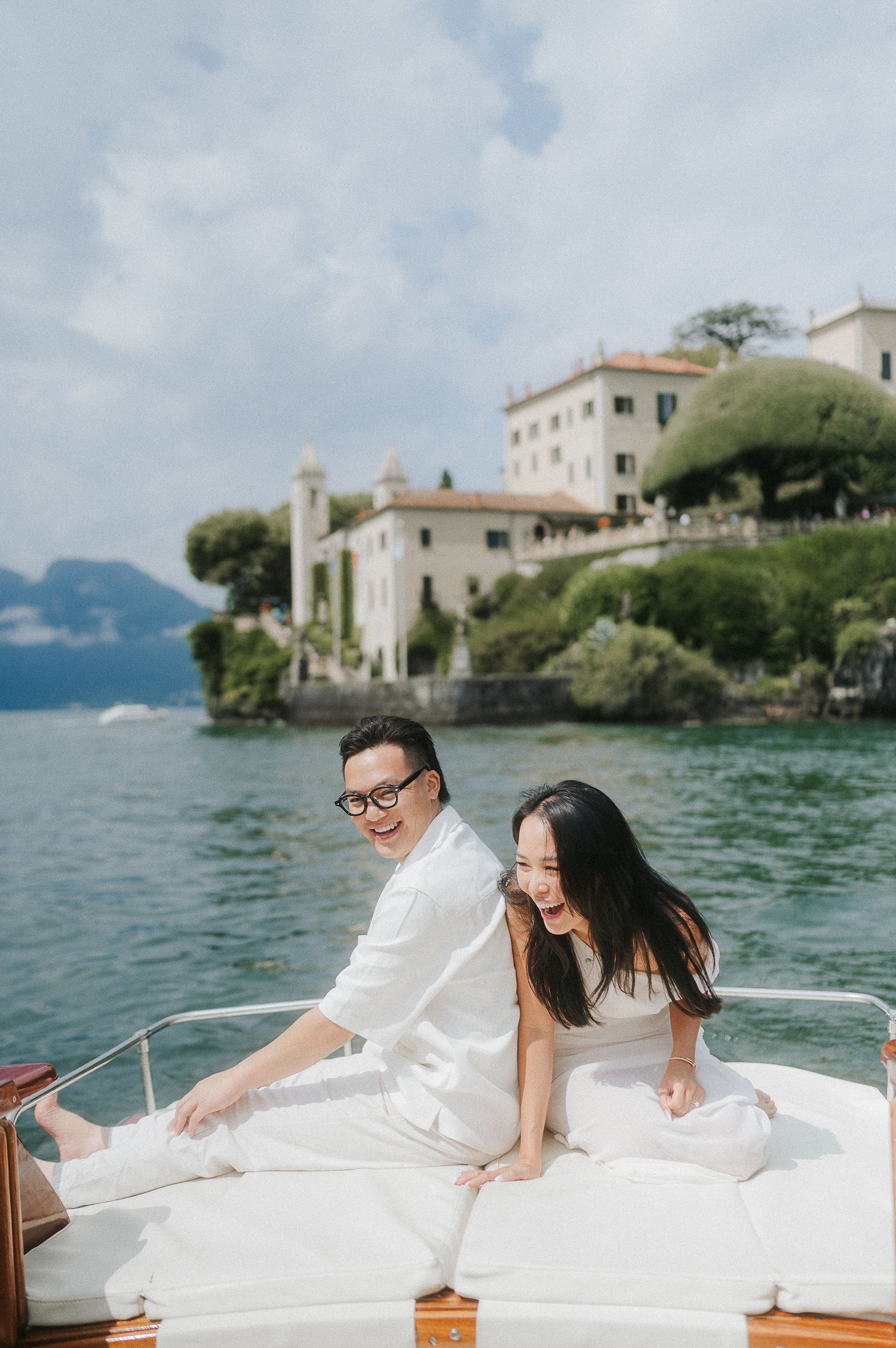 Couple on boat with Lake Como villa during engagement session