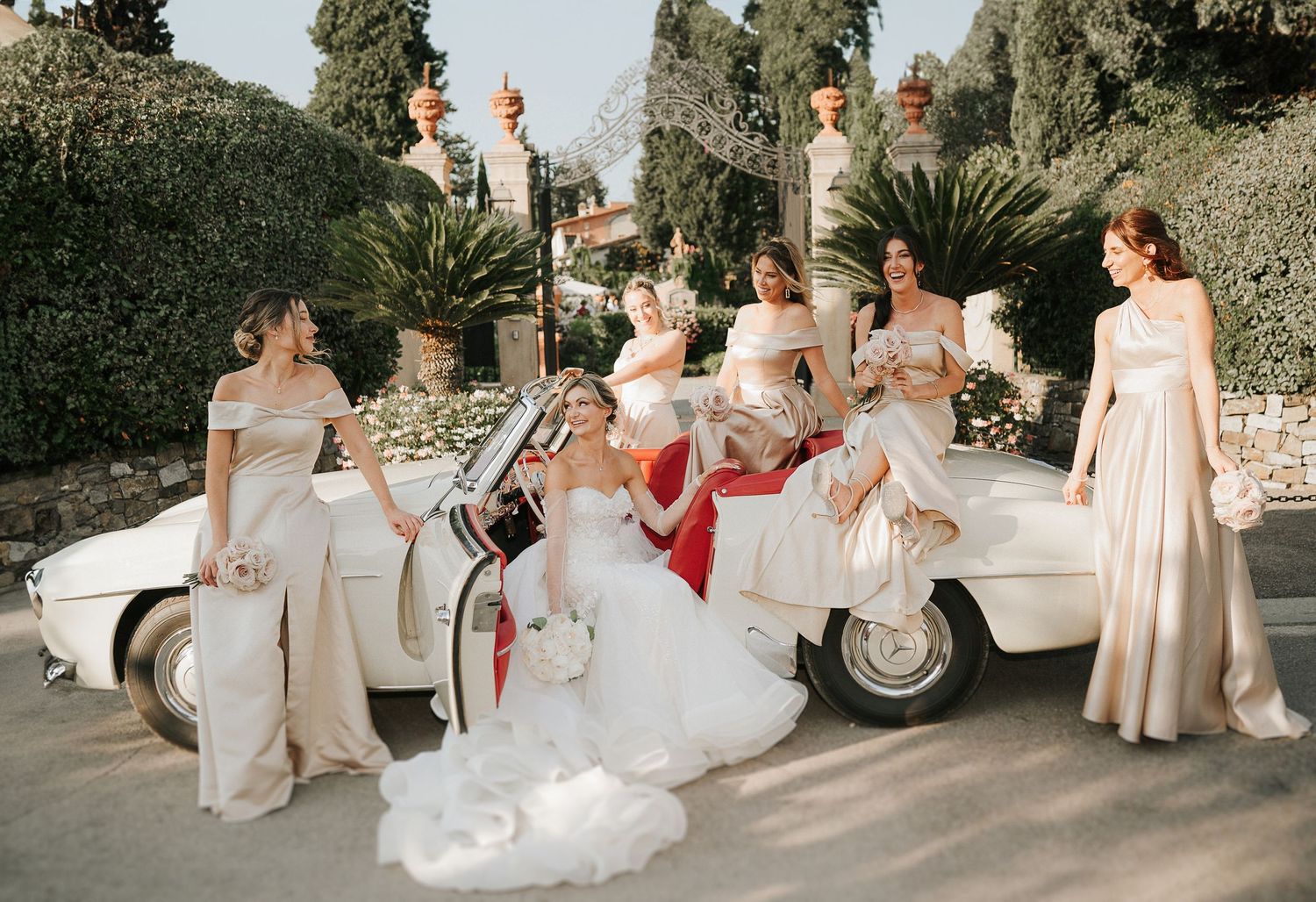 Bridal party portrait with vintage car captured during a luxury wedding in the Tuscan countryside