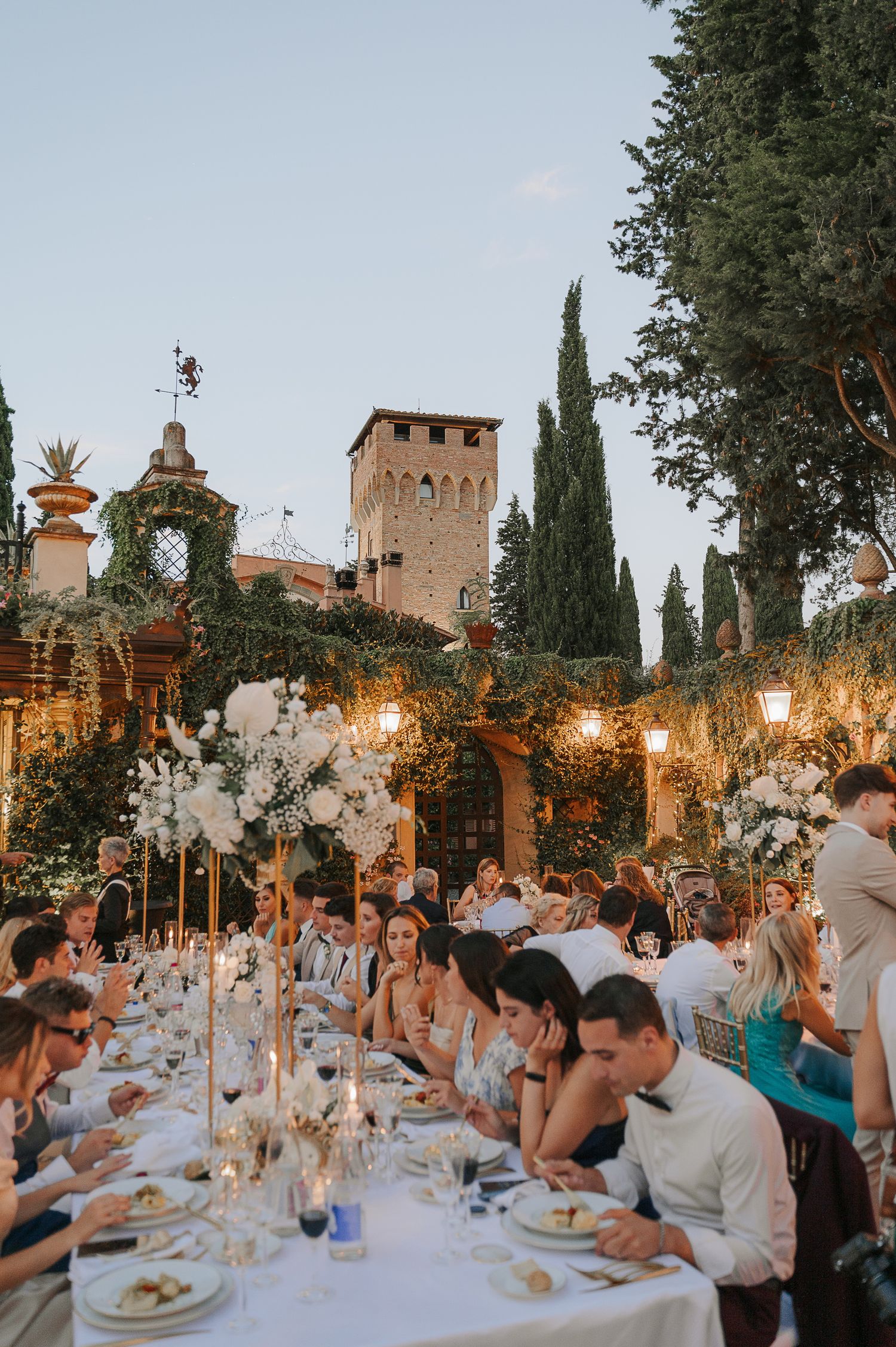 Outdoor wedding dinner in Tuscany, Italy, captured during a refined celebration with warm light and elegant atmosphere