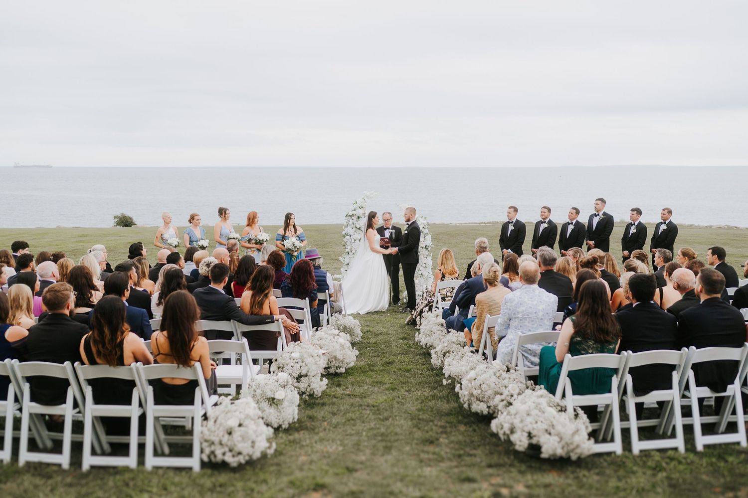 Outdoor wedding ceremony set in a natural landscape, photographed with a clean and editorial style
