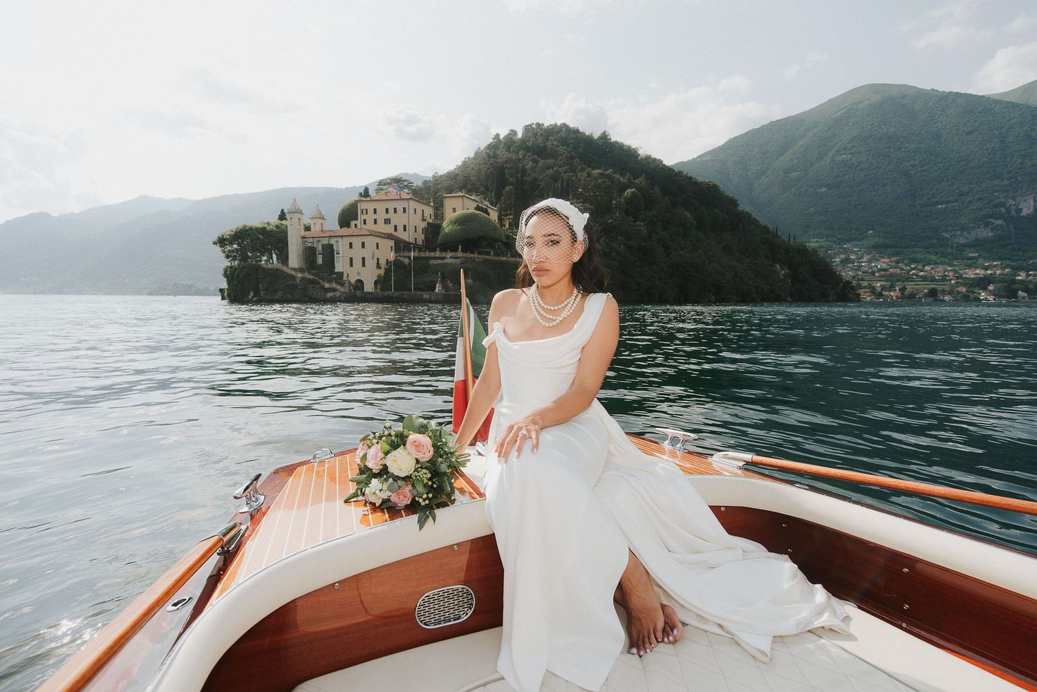 Bride on wooden boat in front of Villa del Balbianello Lake Como