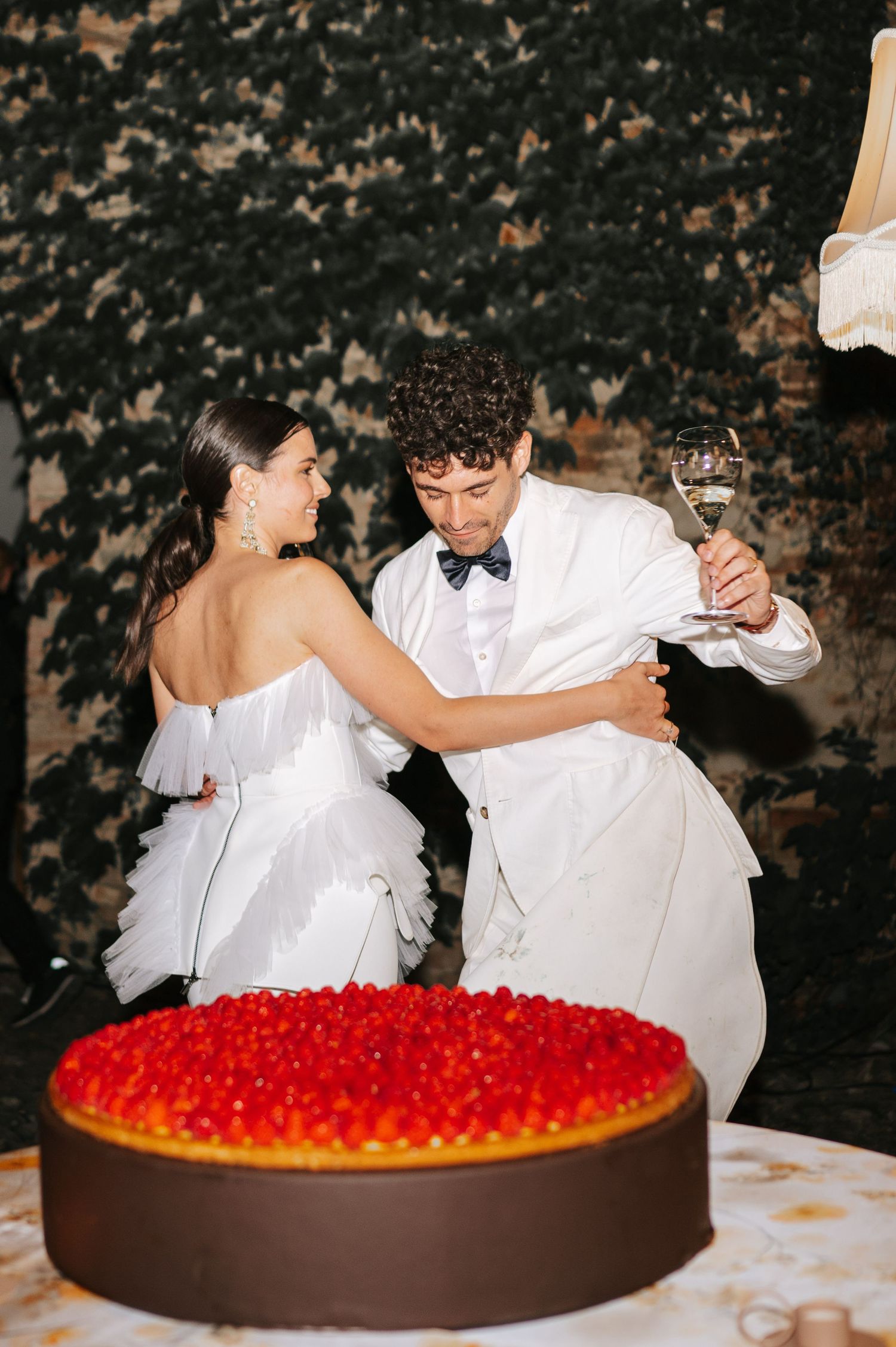 Bride and groom cutting the wedding cake during a romantic Tuscany wedding celebration