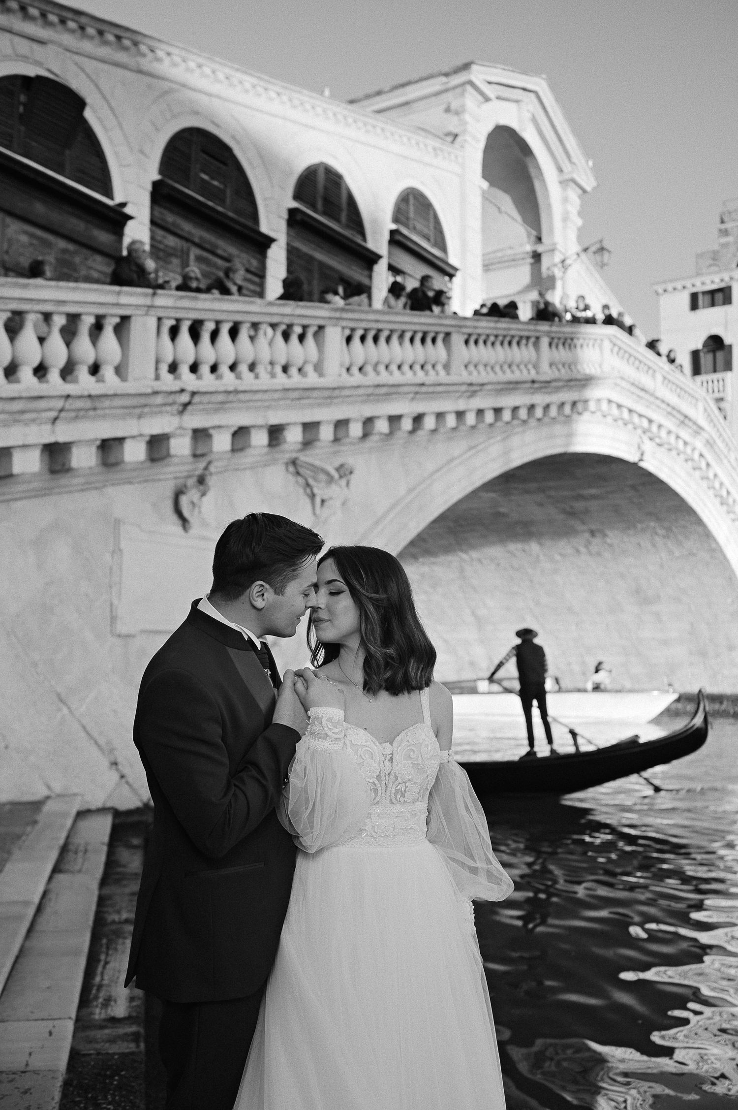 Black and white post-wedding portrait under a historic Venetian bridge, captured with a timeless editorial approach
