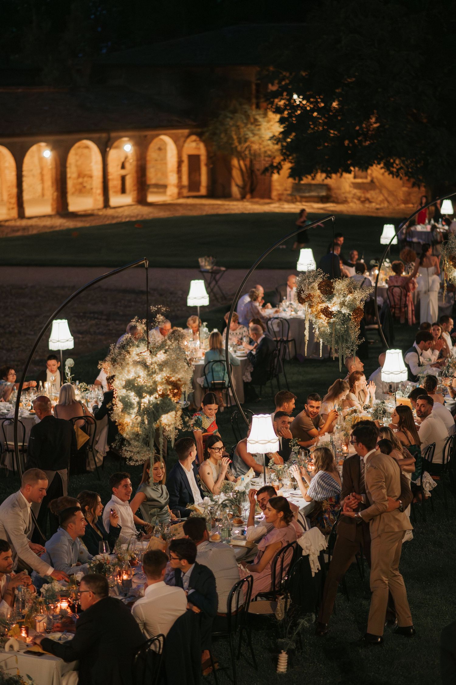 Elegant outdoor wedding dinner illuminated by candlelight during a luxury wedding in Tuscany