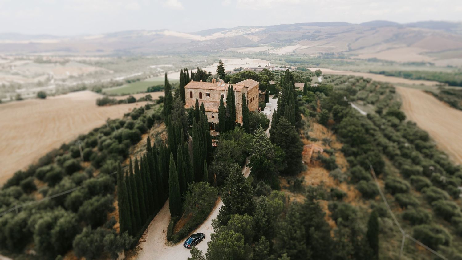 Aerial view of a luxury wedding venue surrounded by rolling hills in Tuscany, Italy