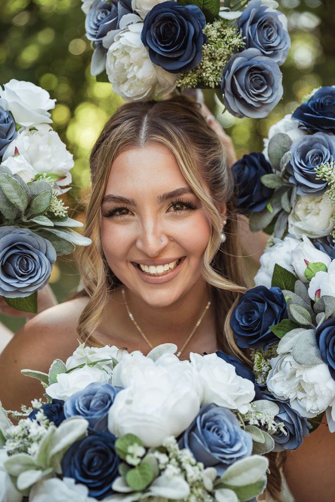 Bride surrounded by flowers during her fall wedding at Camp Waziyatah in Waterford, Maine captured by illuminate the stars Photography