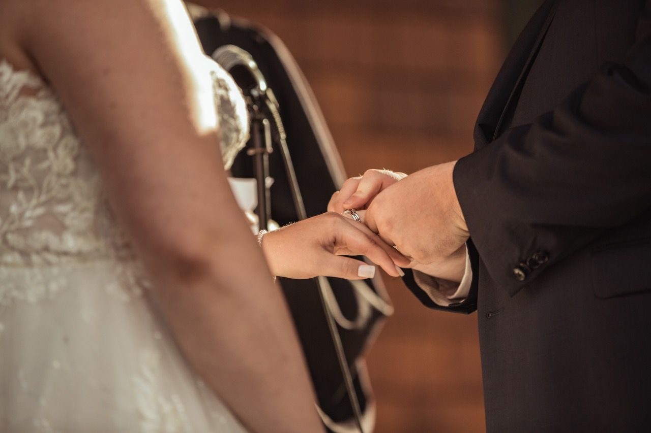 Wedding ring being put on bride at fall wedding ceremony at Camp Dudley in Westport, New York captured by illuminate the stars Photography