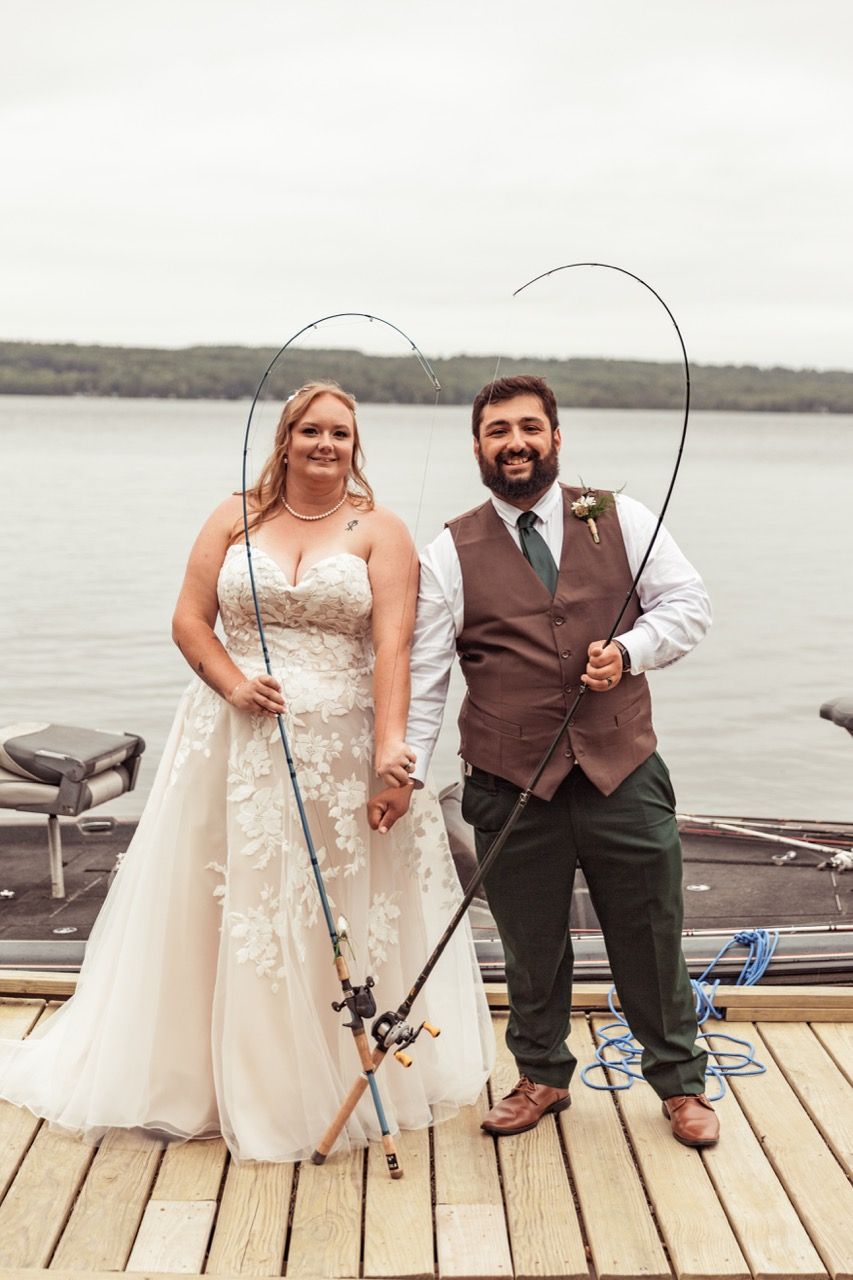 Couple with fishing poles shaped in a heart for wedding at The Lakeside Lodge in Sydney, Maine captured by illuminate the stars Photography