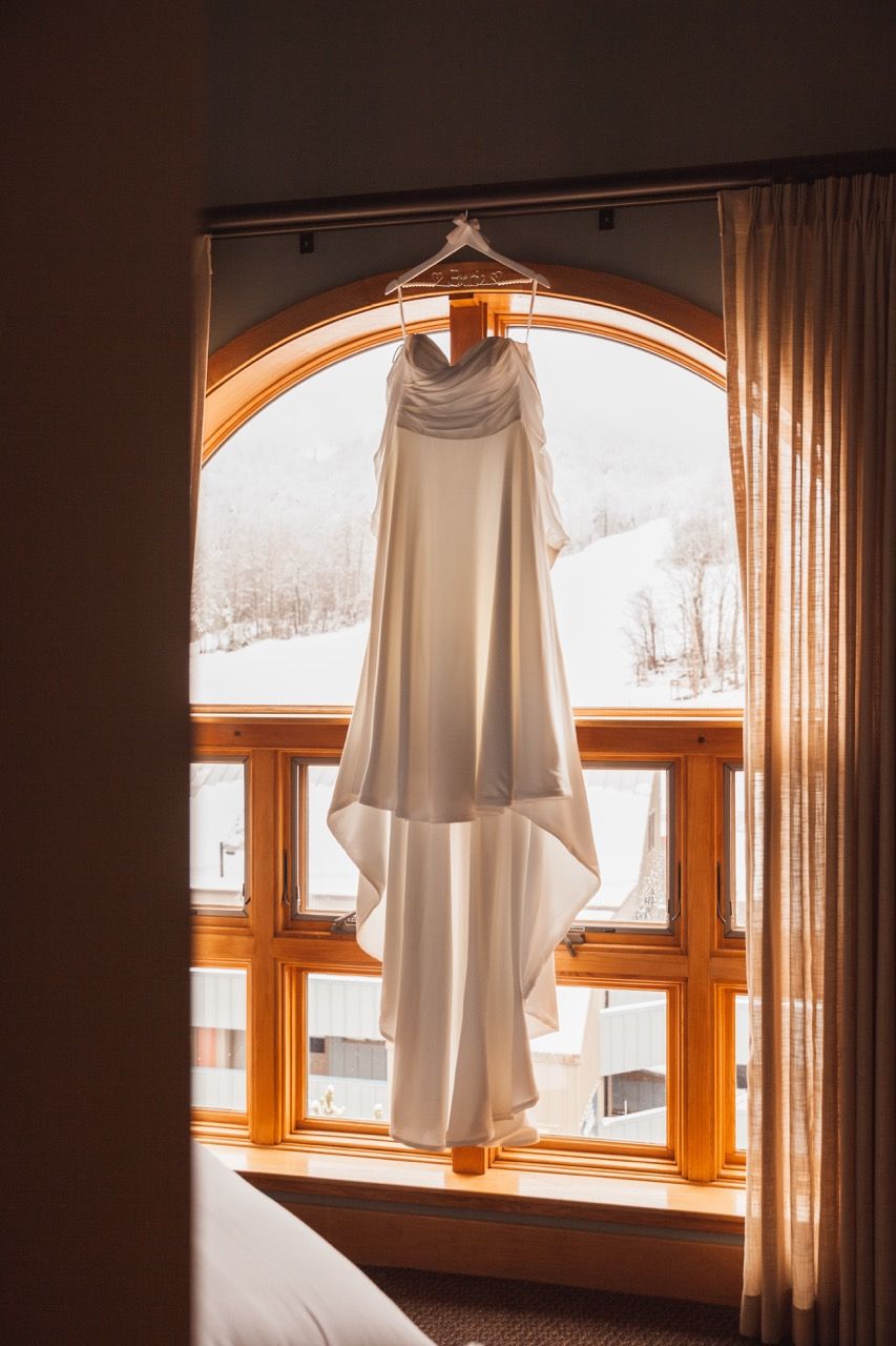 Dress hangin before winter wedding at Sugarloaf Mountain Resort in Carrabassett Valley, Maine captured by illuminate the stars Photography
