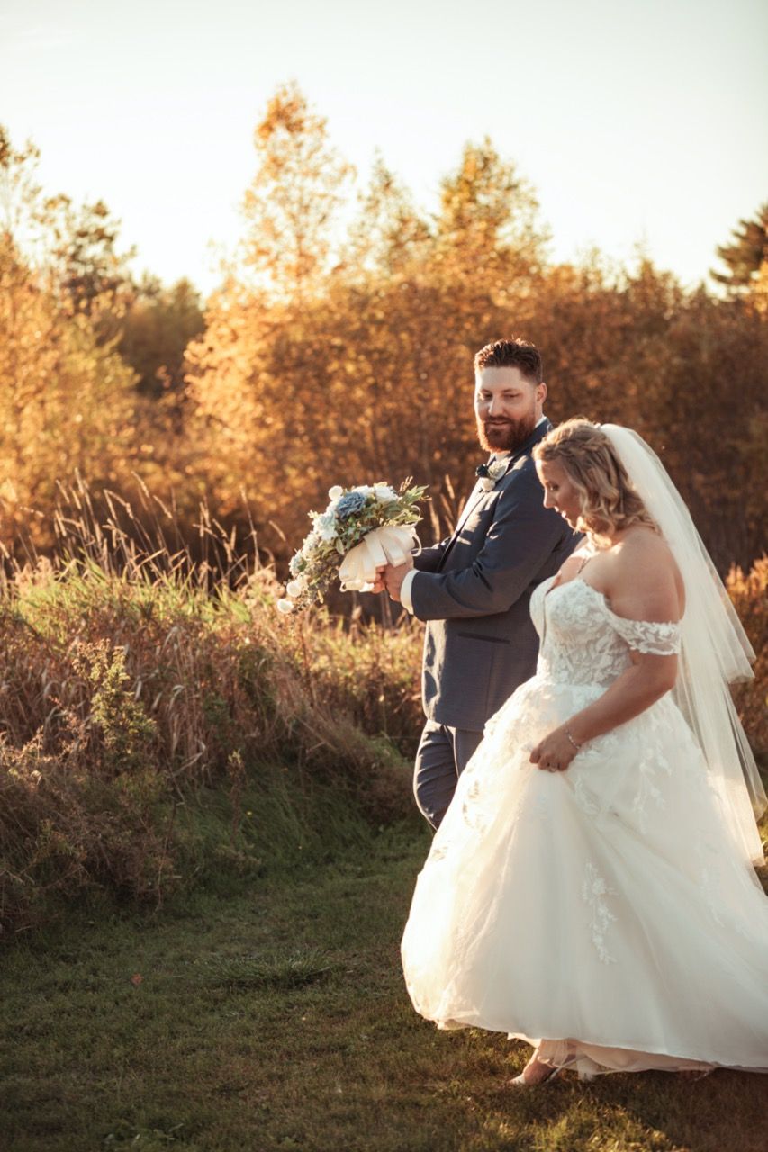 Groom looking at bride while walking at wedding at Morgan Hill Event Center in Herman, Maine captured by illuminate the stars Photography