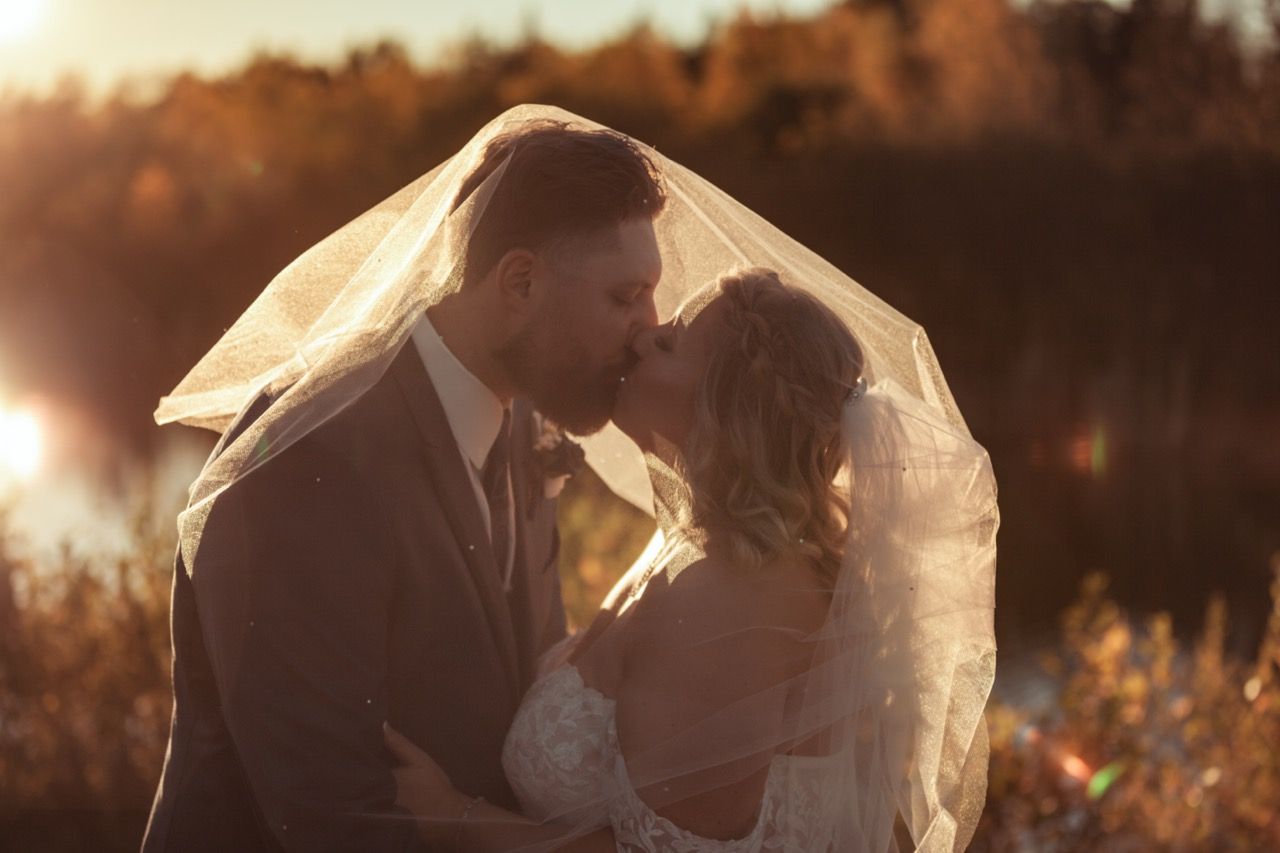 Bride and groom kissing at sunset for wedding at Morgan Hill Event Center in Herman, Maine captured by illuminate the stars Photography