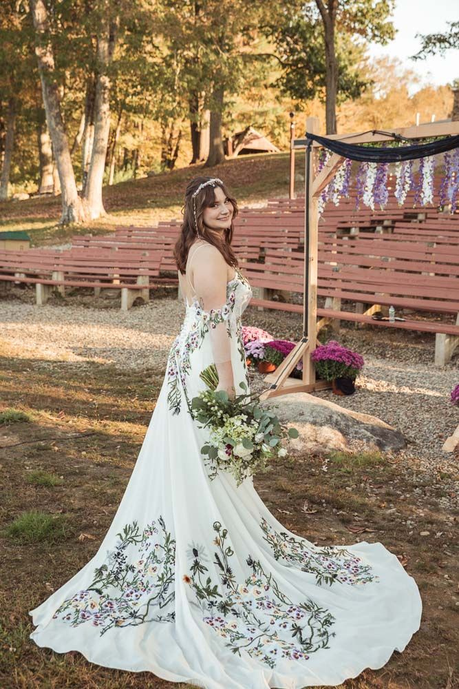 Bride in her floral wedding dress during her fall wedding at June Norcross camp in Ashford, CT captured by illuminate the stars Photography