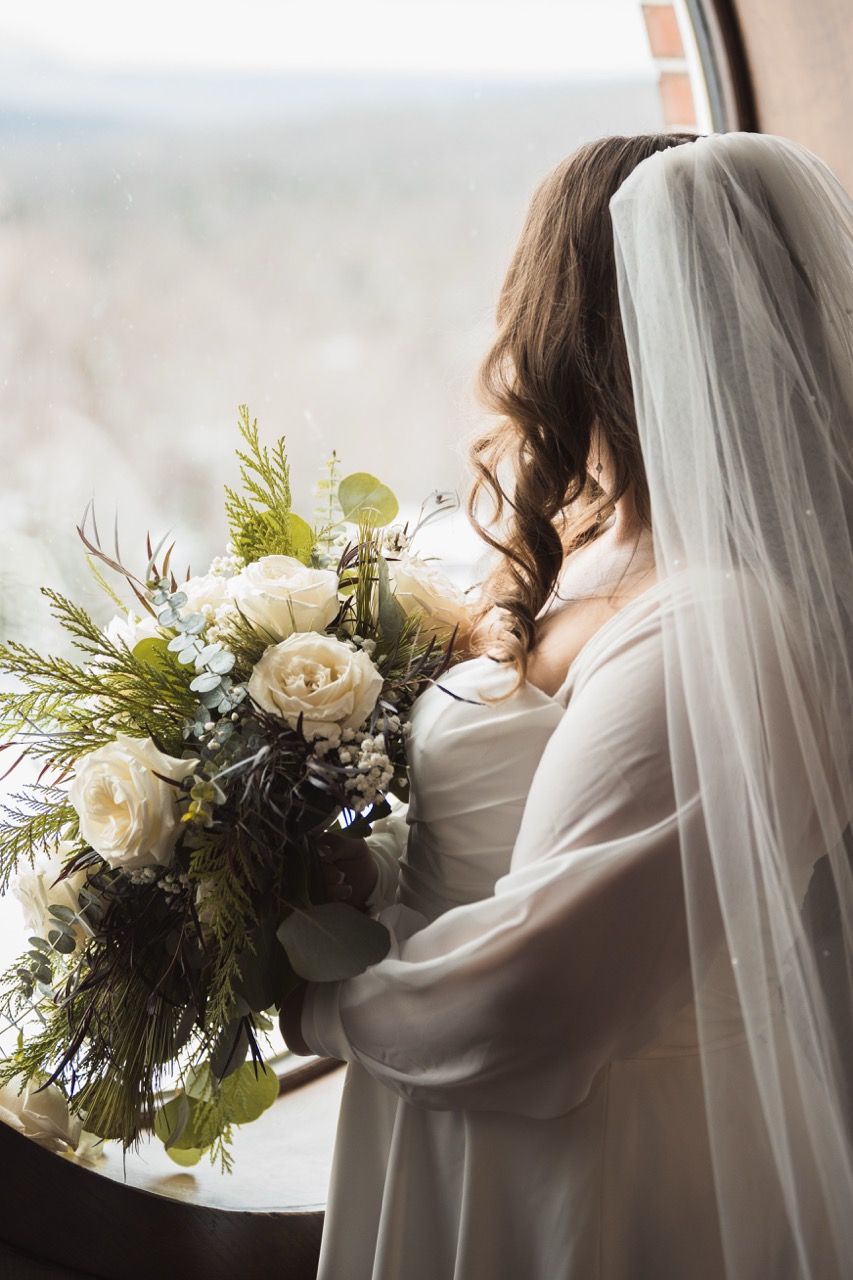 Bride in window for winter wedding at Sugarloaf Mountain Resort in Carrabassett Valley, Maine captured by illuminate the stars Photography