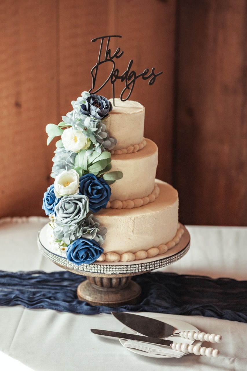 Three tiered wedding cake with flowers at wedding at Morgan Hill Event Center in Herman, Maine captured by illuminate the stars Photography