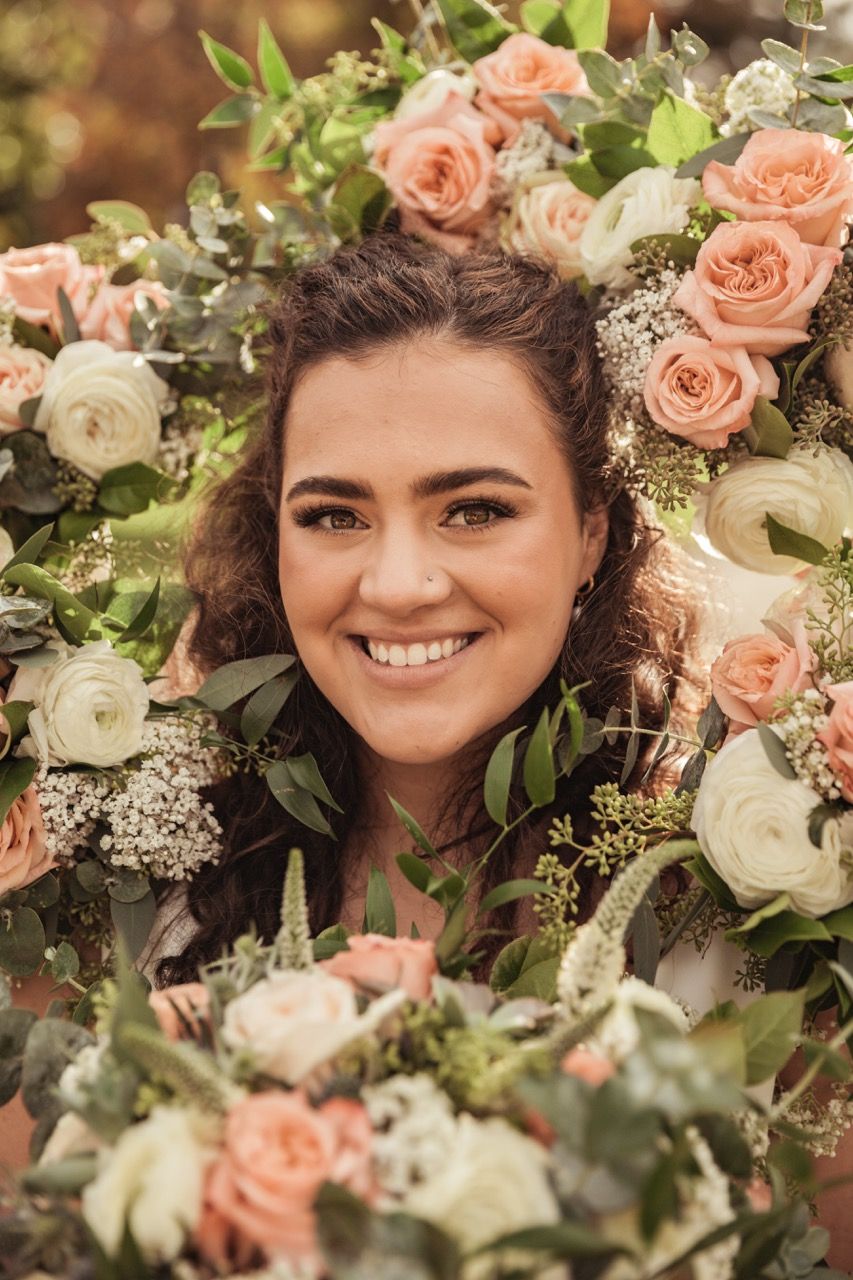 Bride surrounded by flowers during her fall wedding at Beech Hill Barn in Pittston, Maine captured by illuminate the stars Photography