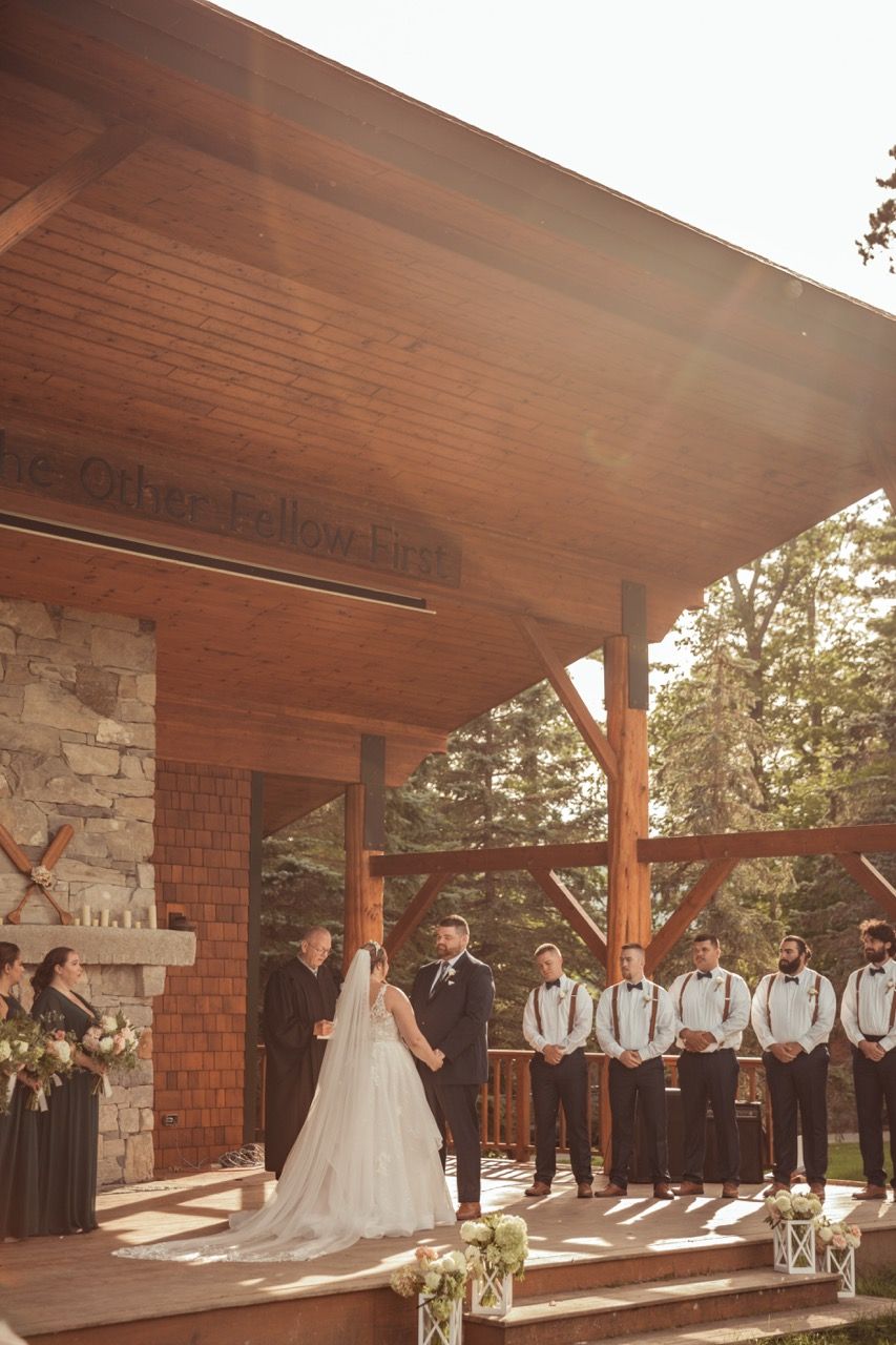 Couple holding hands during their fall wedding ceremony at Camp Dudley in Westport, New York captured by illuminate the stars Photography
