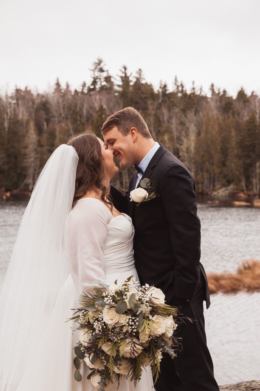Couple kissing for winter wedding at Sugarloaf Mountain Resort in Carrabassett Valley, Maine captured by illuminate the stars Photography