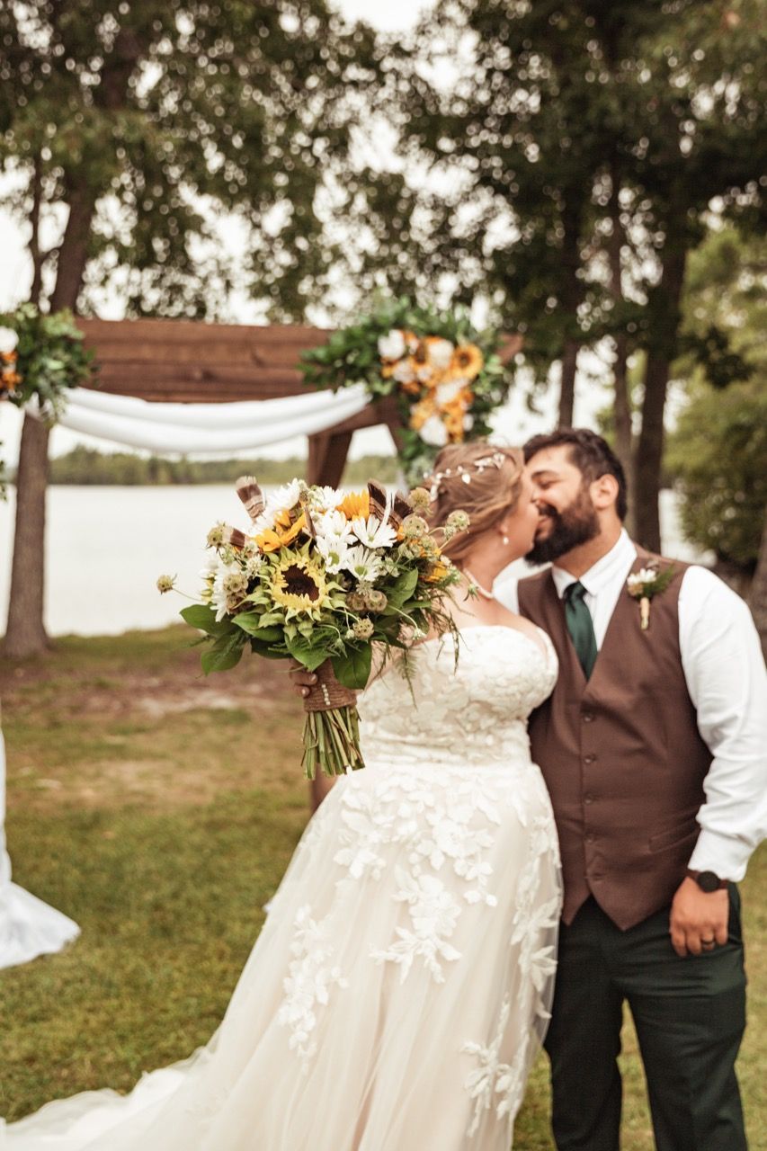 Couple holding out flowers during their wedding at The Lakeside Lodge in Sidney, Maine captured by illuminate the stars Photography