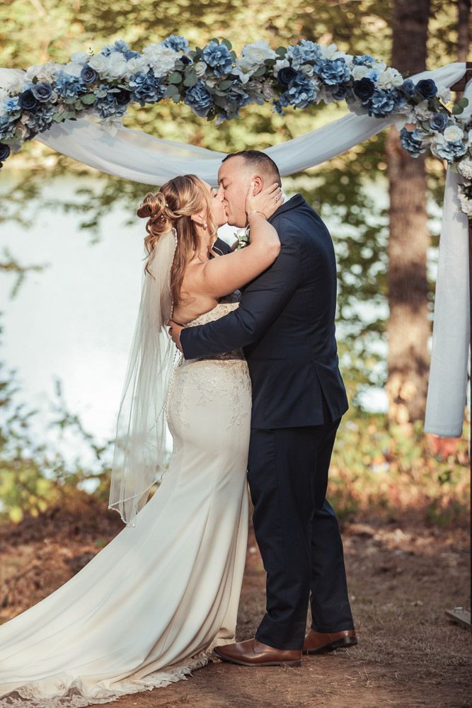 Couple's first kiss during their fall wedding at Camp Waziyatah in Waterford, Maine captured by illuminate the stars Photography