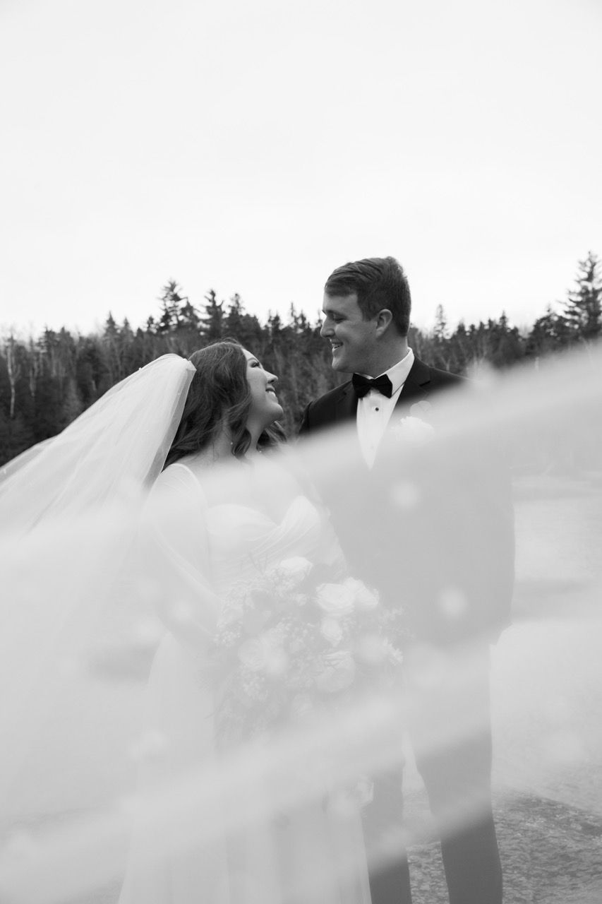 Couple and veil for winter wedding at Sugarloaf Mountain Resort in Carrabassett Valley, Maine captured by illuminate the stars Photography