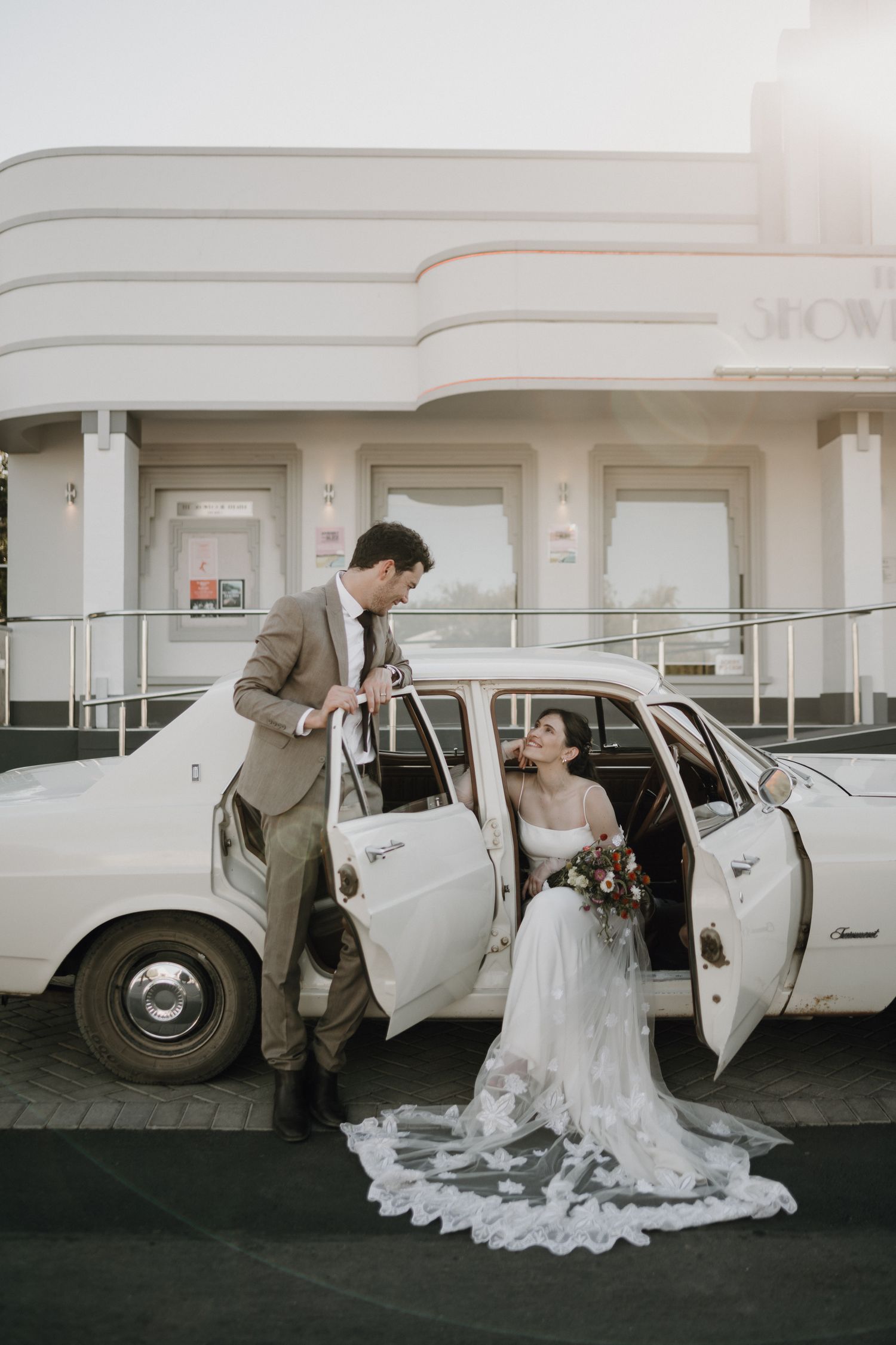 Couple portrait with wedding car in front of The Showroom Theatre Prince Albert