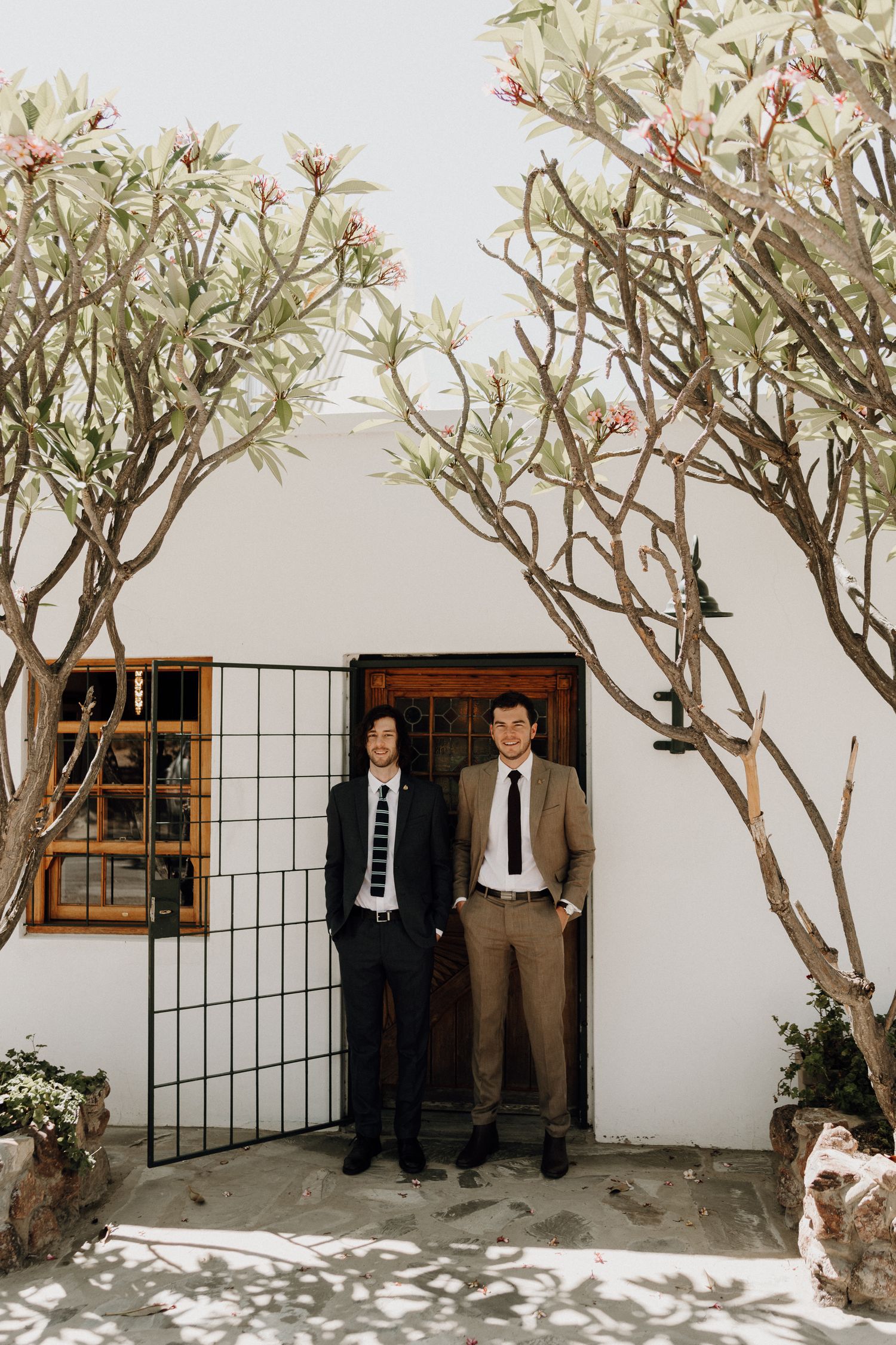 Groom and his brother getting ready at Prince Albert Cottage portrait of them together beneath the frangipani tree in De Beer Street