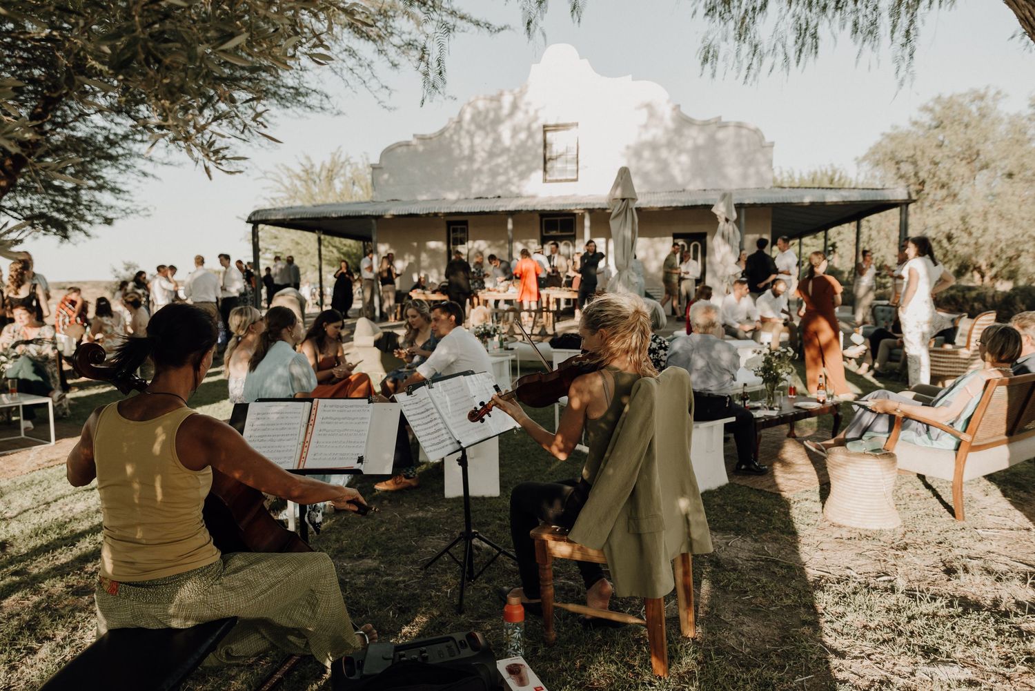 Violinist entertaining guests during canapés in front of old Cape Dutch farm house Abrahamskraal Guest Farm Prince Albert Karoo