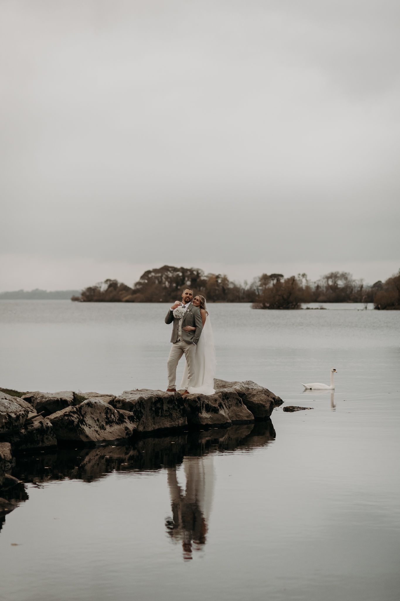 Bride and groom portrait with swans on Lough Leane at Ross Castle, Ireland