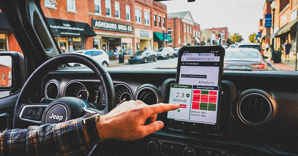 Car dashboard view showing navigation system and interior controls while driving through city streets.