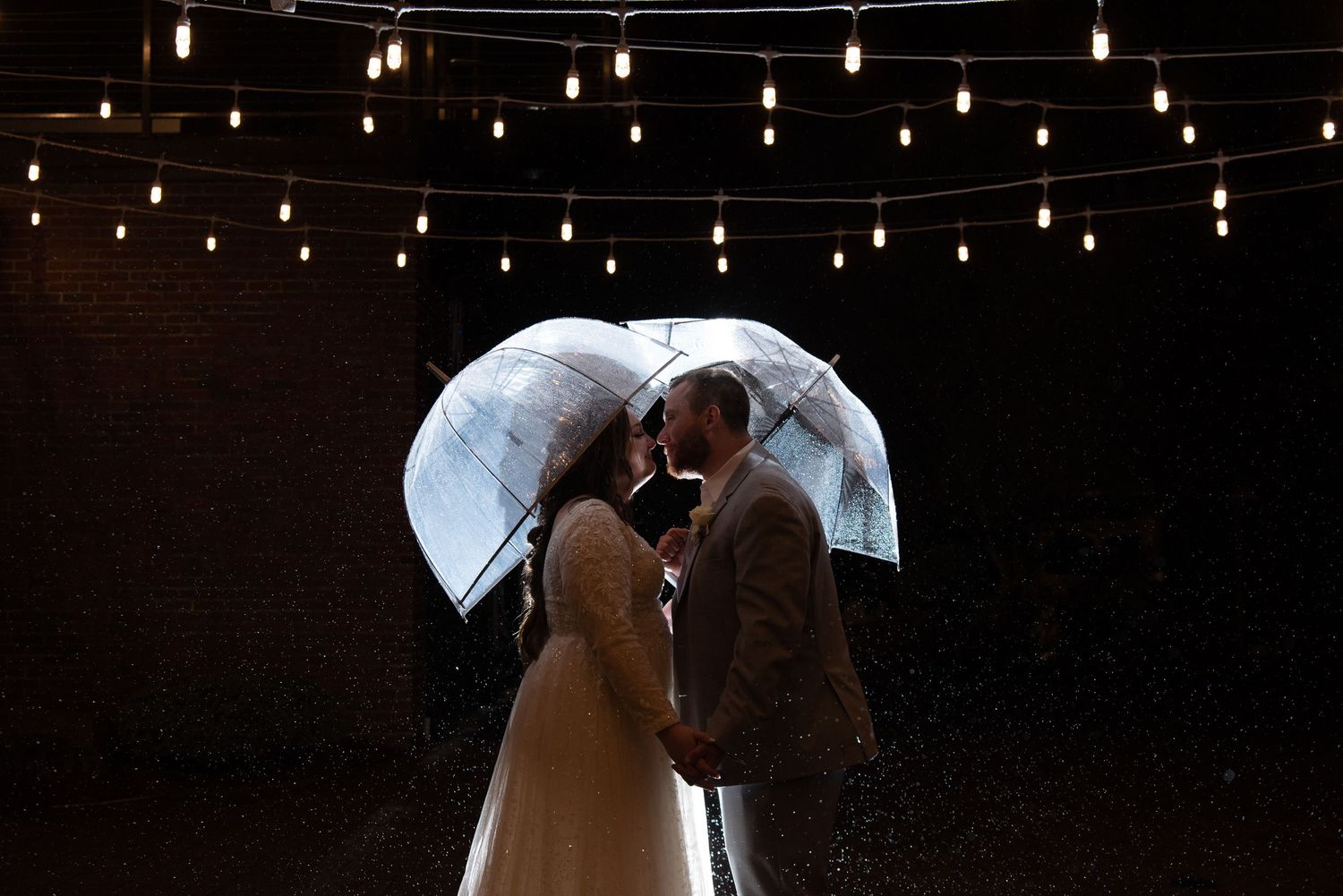 Bride and groom sharing an umbrella during a rainy wedding day in New Hampshire.