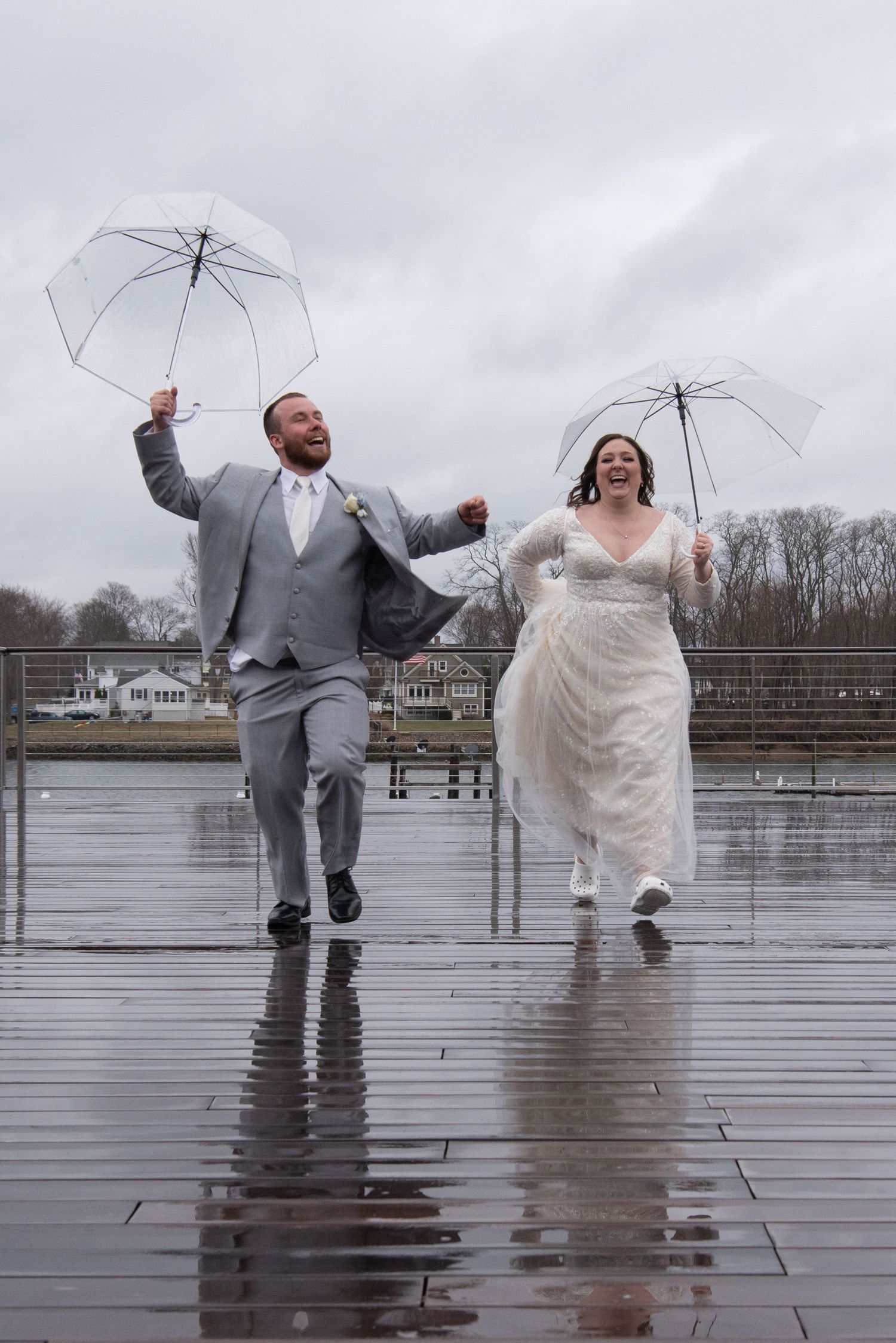 Bride and groom sharing an umbrella during a rainy wedding day in New Hampshire.