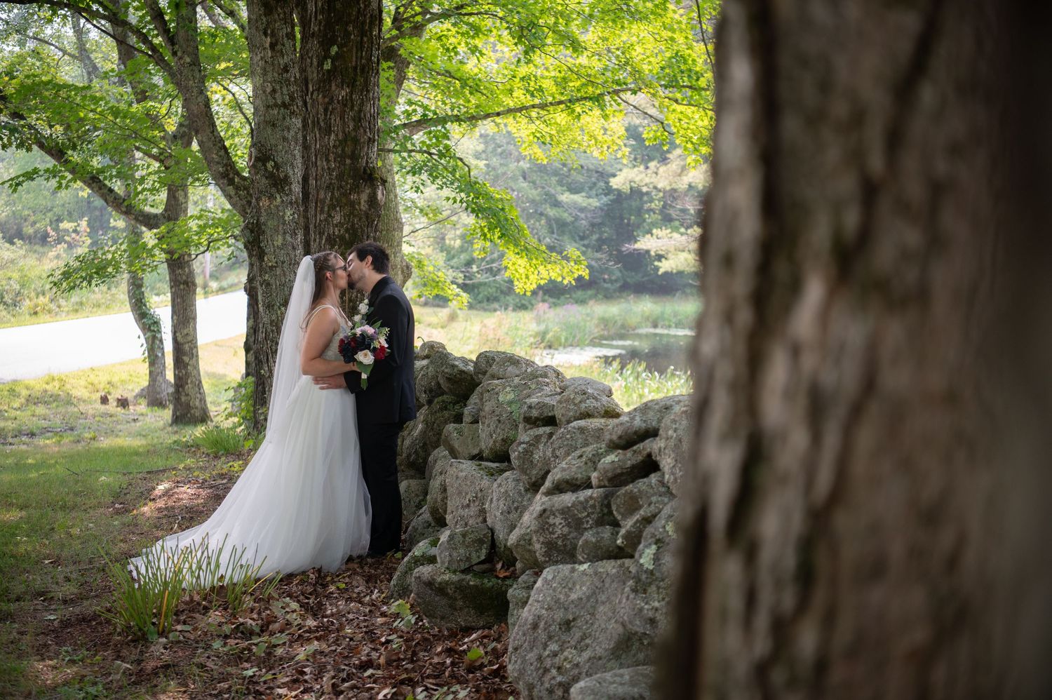 Couple embracing inside a rustic barn during their New Hampshire wedding day.