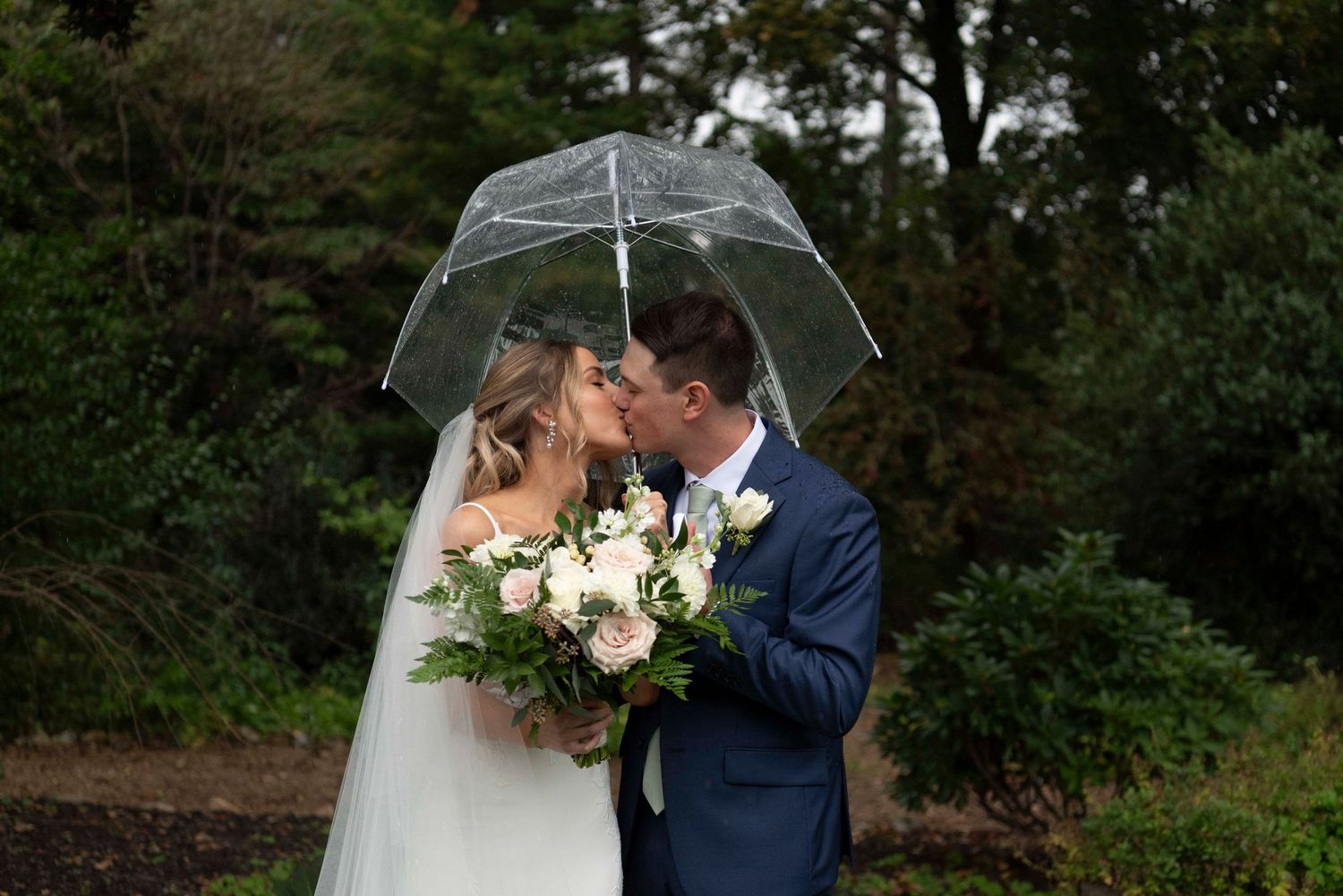 Couple embracing in the rain during their outdoor New Hampshire wedding.