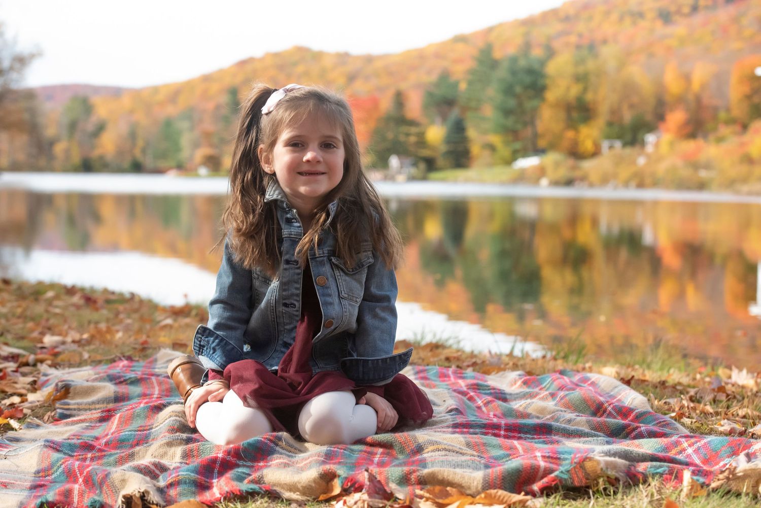 Family photo session in a New Hampshire field during golden hour, featuring parents and children laughing together.