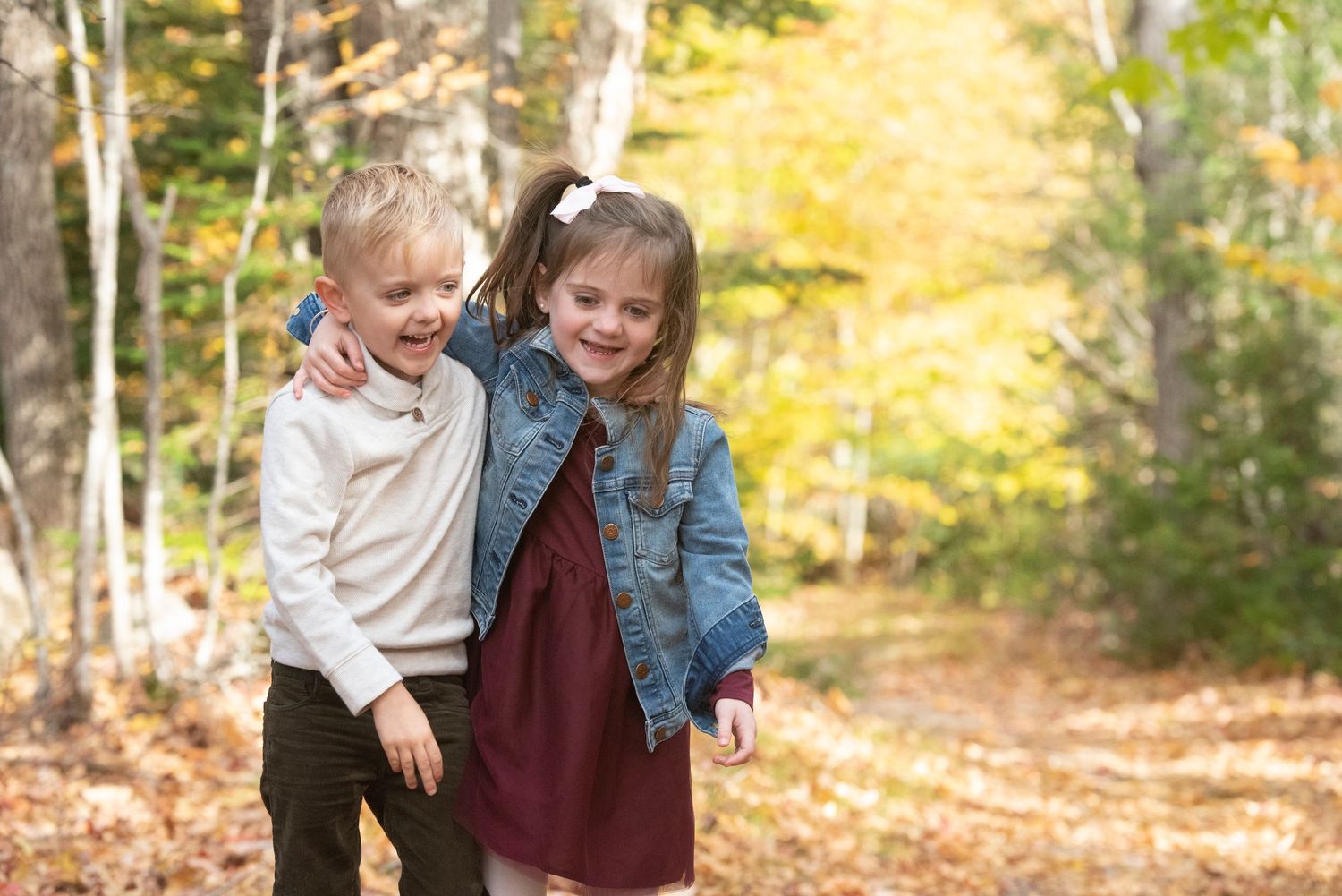 Candid family portraits in the White Mountains of New Hampshire with fall foliage in the background.