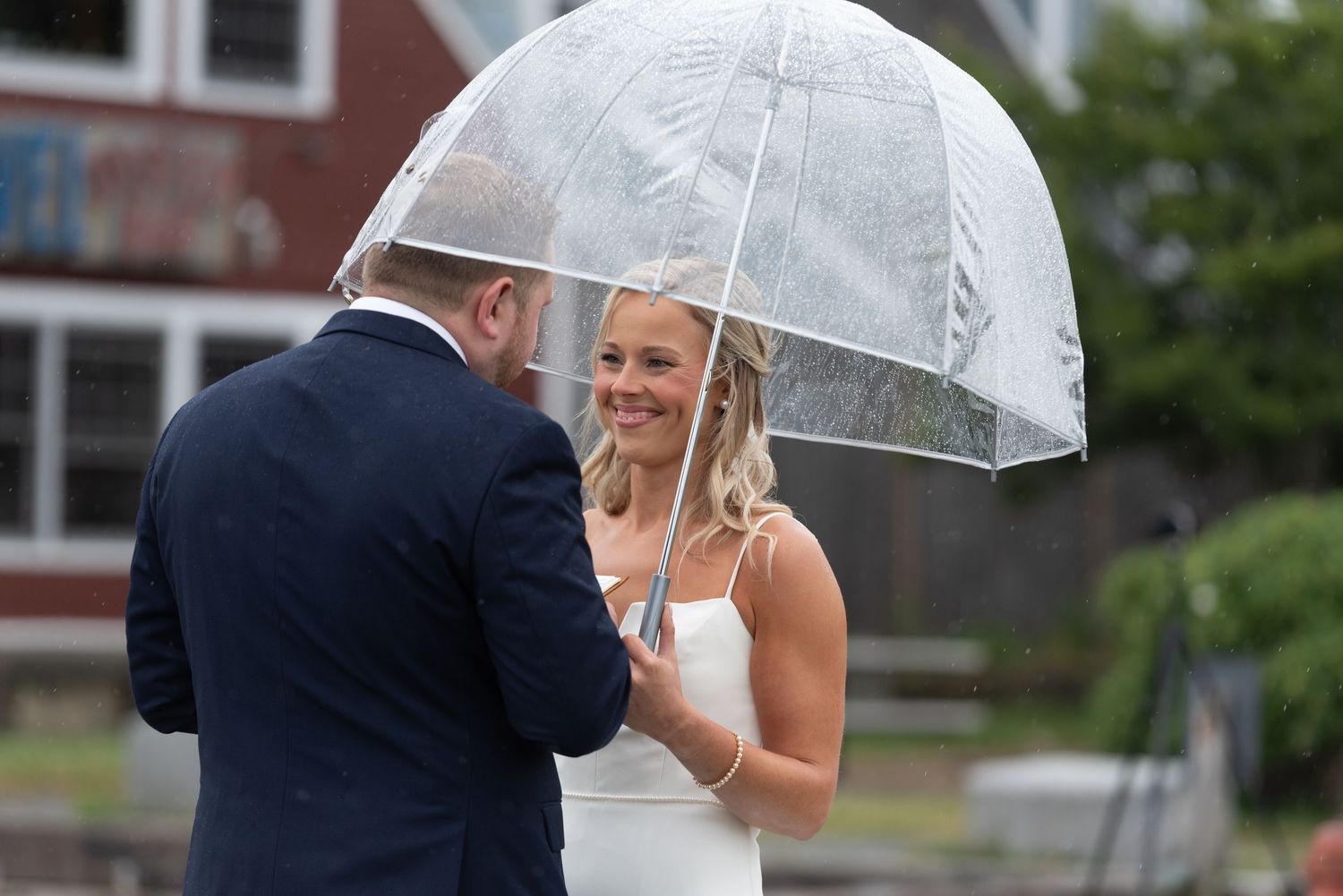 Rain-soaked wedding moment capturing authentic emotion and connection.
