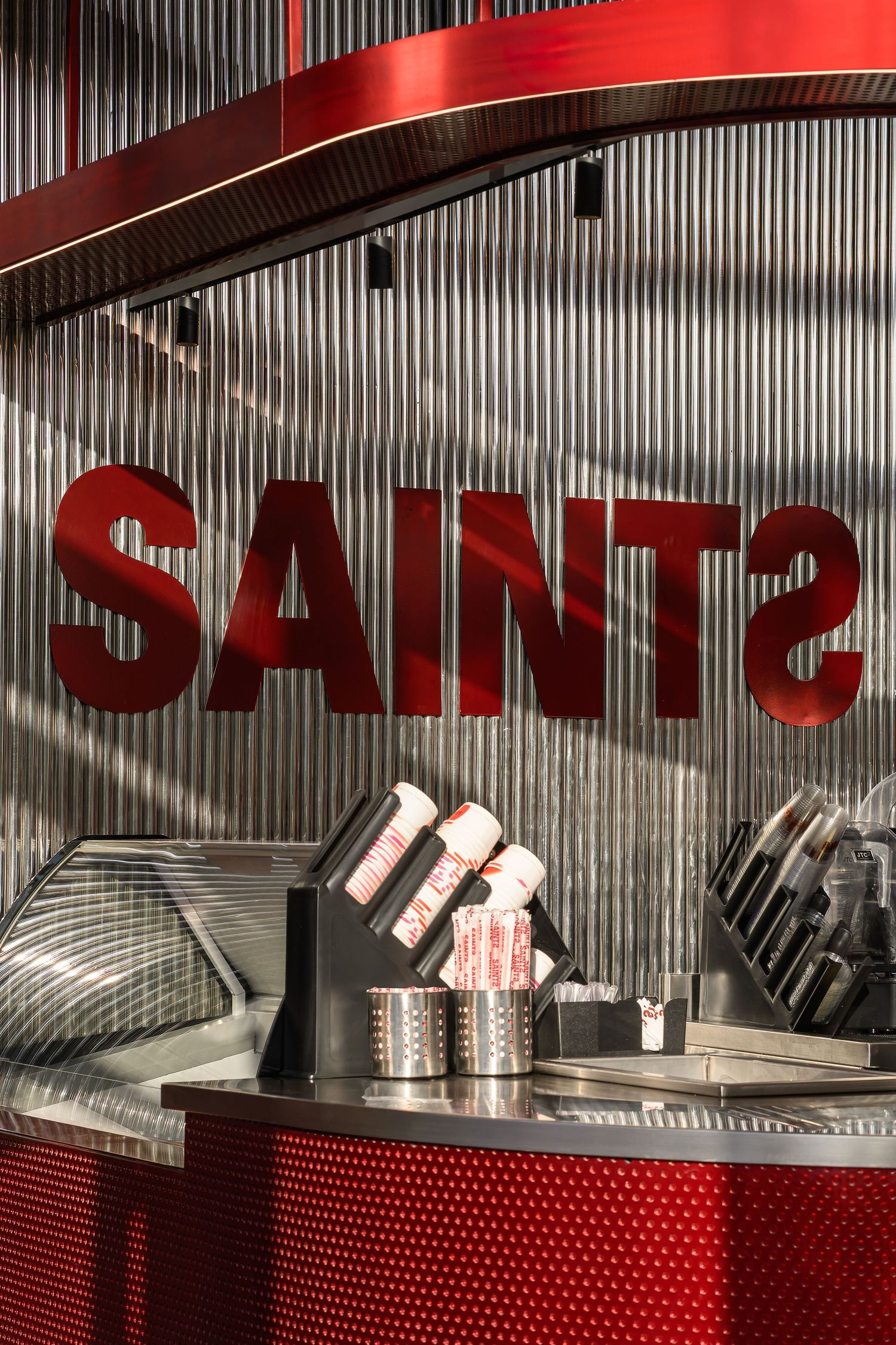 Red and silver restaurant signage with industrial metal design elements. Interior Photography