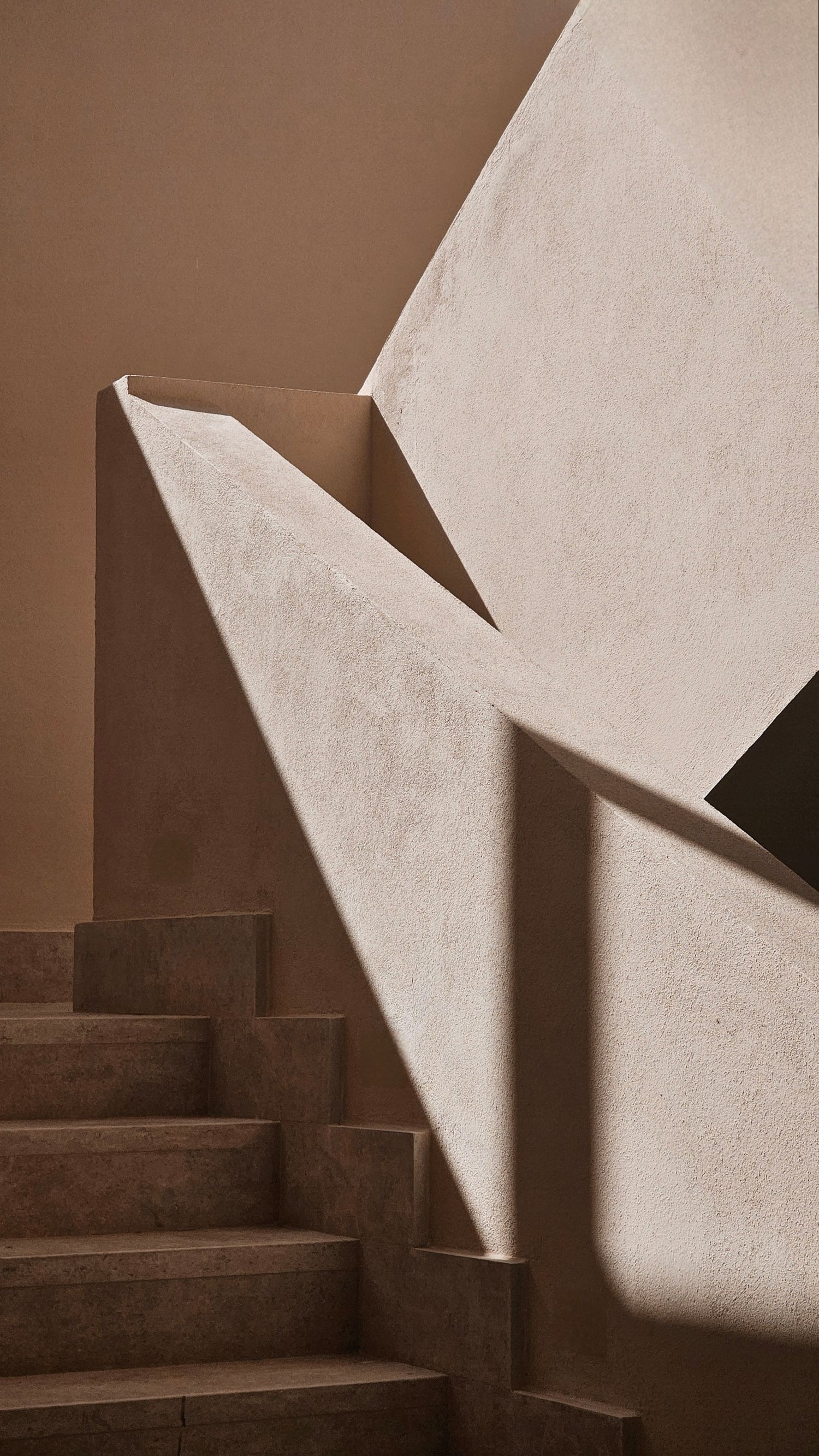Minimalist architectural detail showing dramatic light and shadow play on concrete stairs. Interior Photography