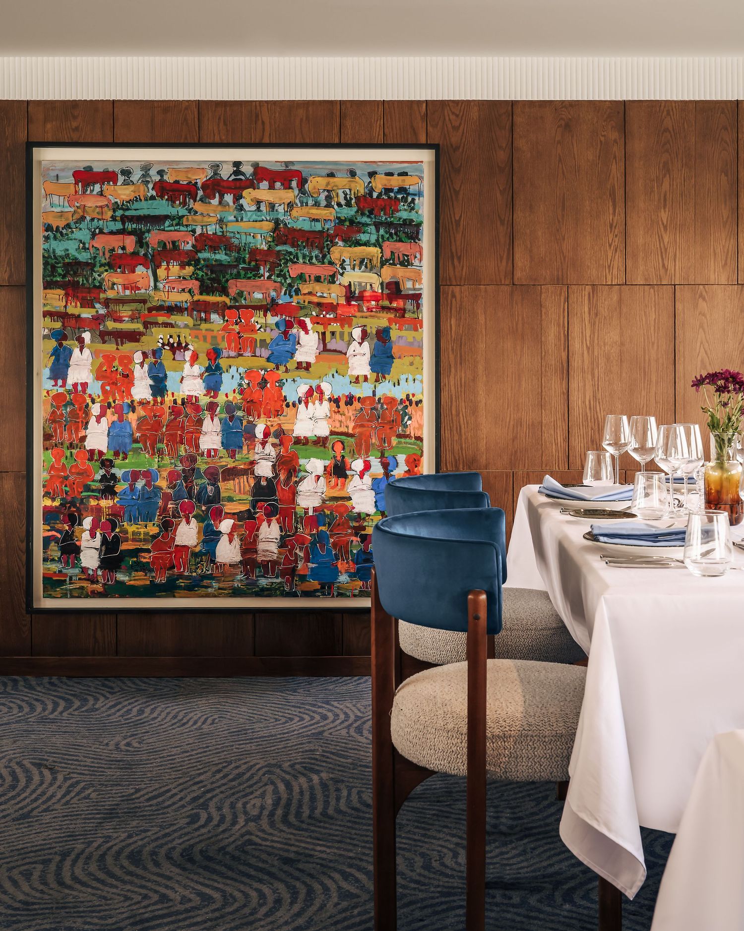 Restaurant interior with colorful artwork and formal table settings. Interior Photography