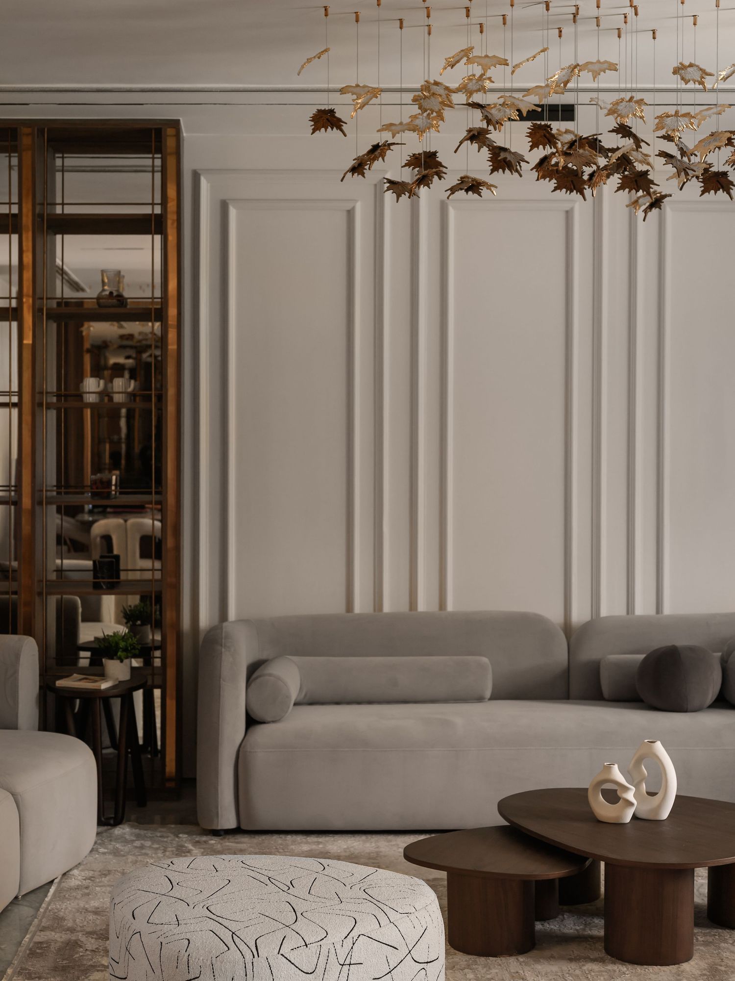 Elegant living room with curved sofa and decorative metallic ceiling installation. Interior Photography